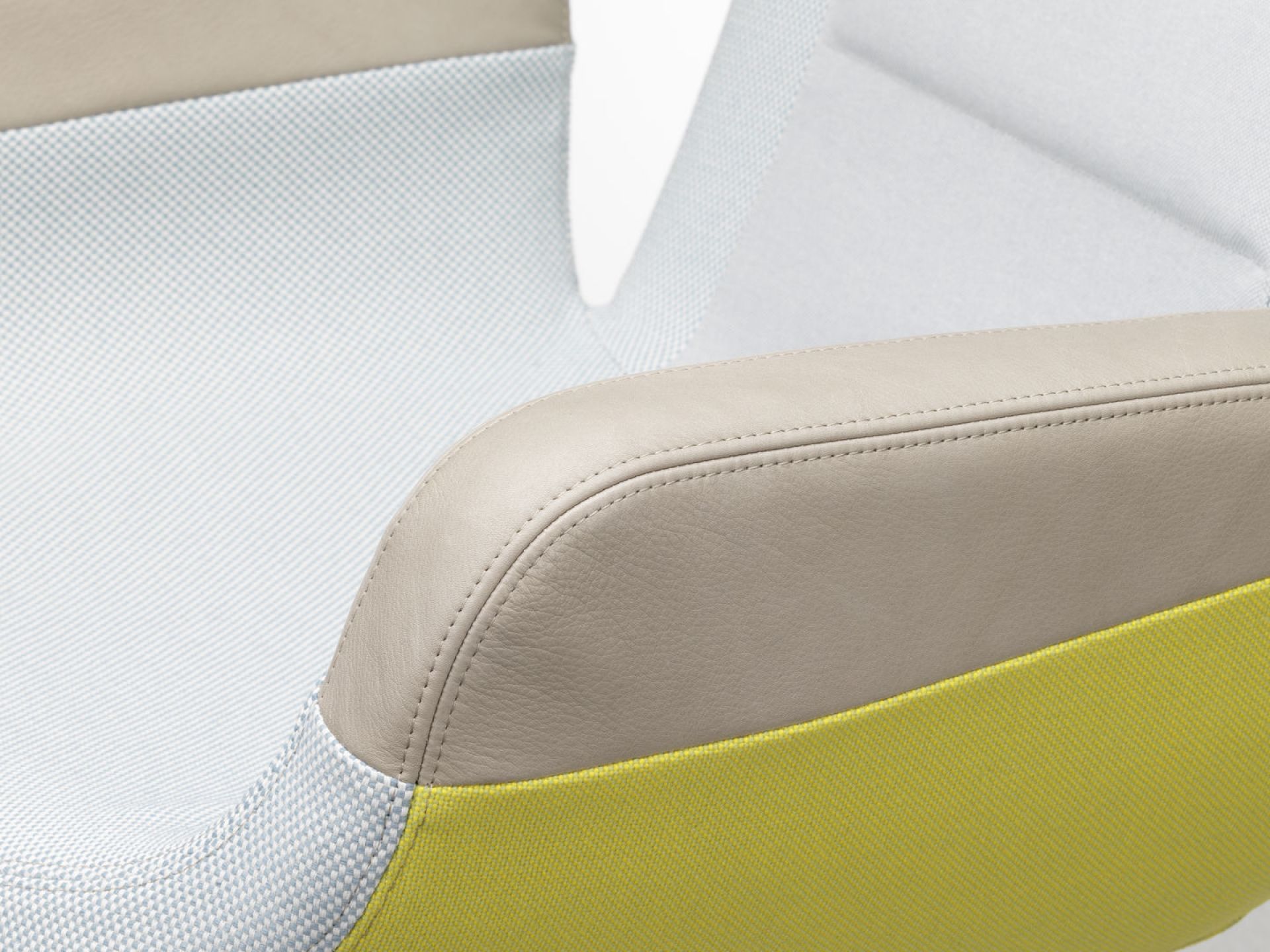 Detailaufnahme vom East River Chair Sessel von Vitra: Lederarmlehne, Textilbezug in Weiß und Gelb.