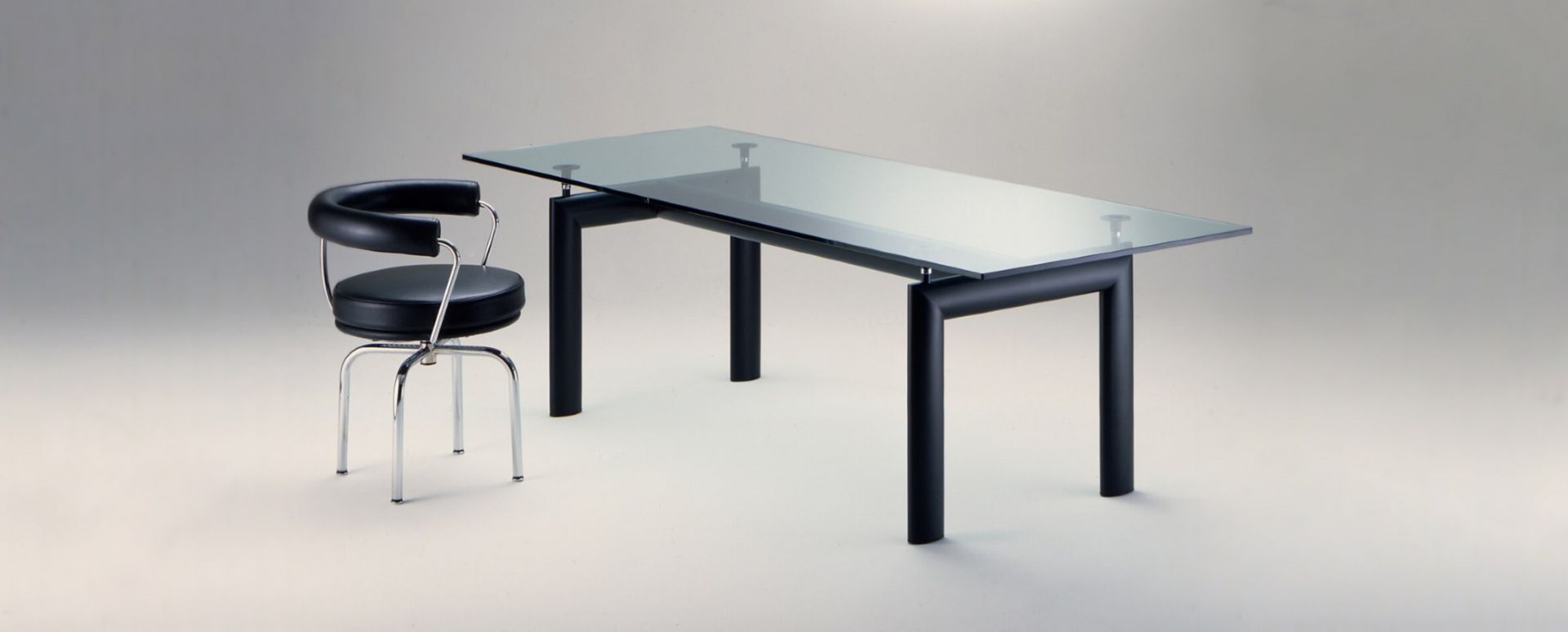 7 Fauteuil Tournant Drehsessel Cassina mit schwarzem Leder und Glas Esstisch im modernen Design.