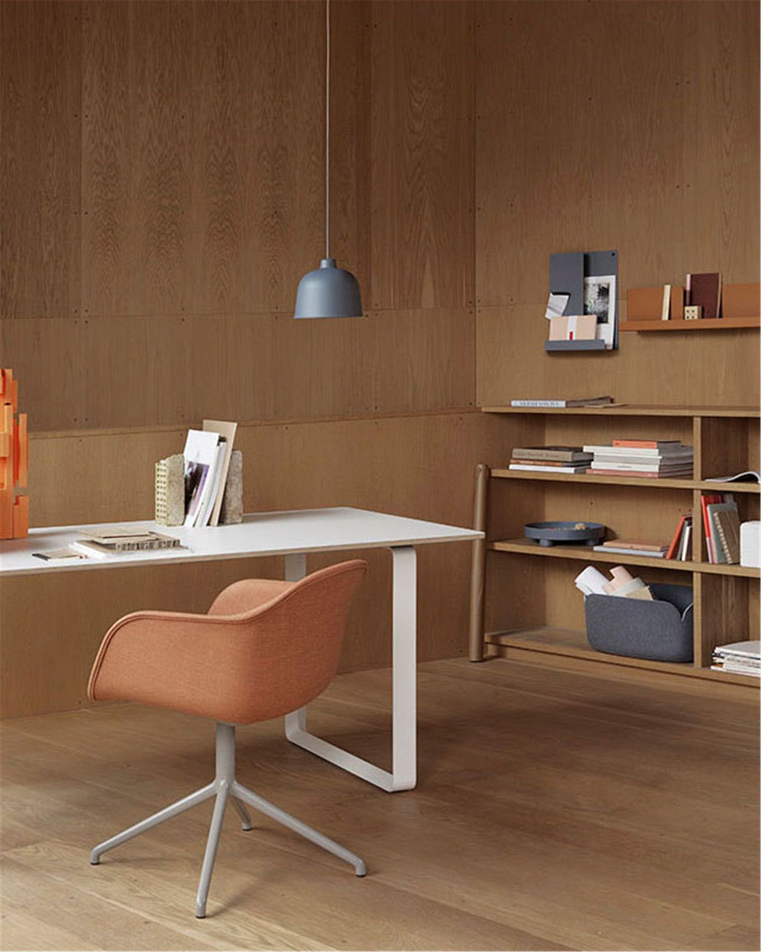 Nahaufnahme der grauen Muuto Grain Pendelleuchte über einem modernen Schreibtisch in einem Büro.