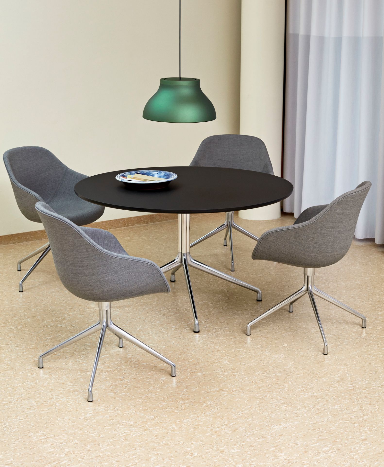 Esstisch mit vier grauen About a Chair AAC 121 Stühlen und grüner Pendelleuchte.