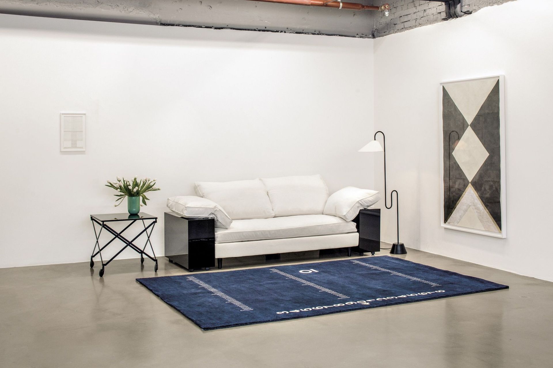 Helles Lota Sofa von Classicon in modernem Wohnraum mit blauem Teppich und Kunst.