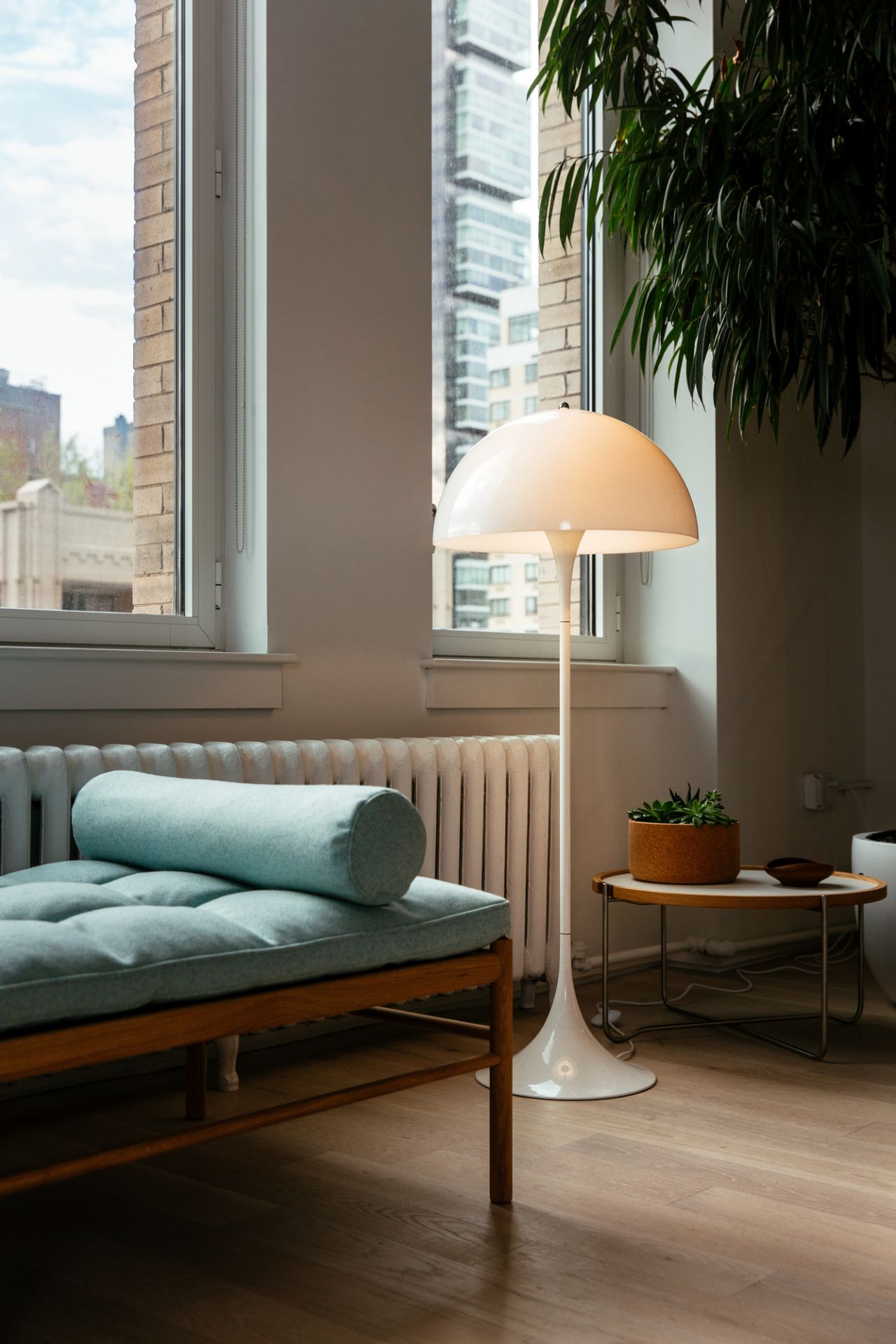 Weiße Panthella Stehleuchte von Louis Poulsen im Wohnzimmer neben einer Couch und einem Beistelltisch.