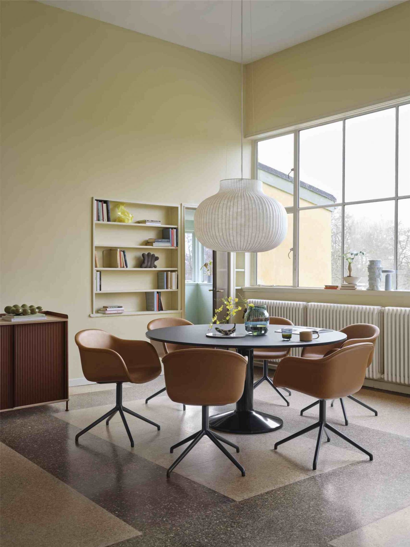 MIDST Table von Muuto: Runder Esstisch mit braunen Stühlen in einem hellen Esszimmer.