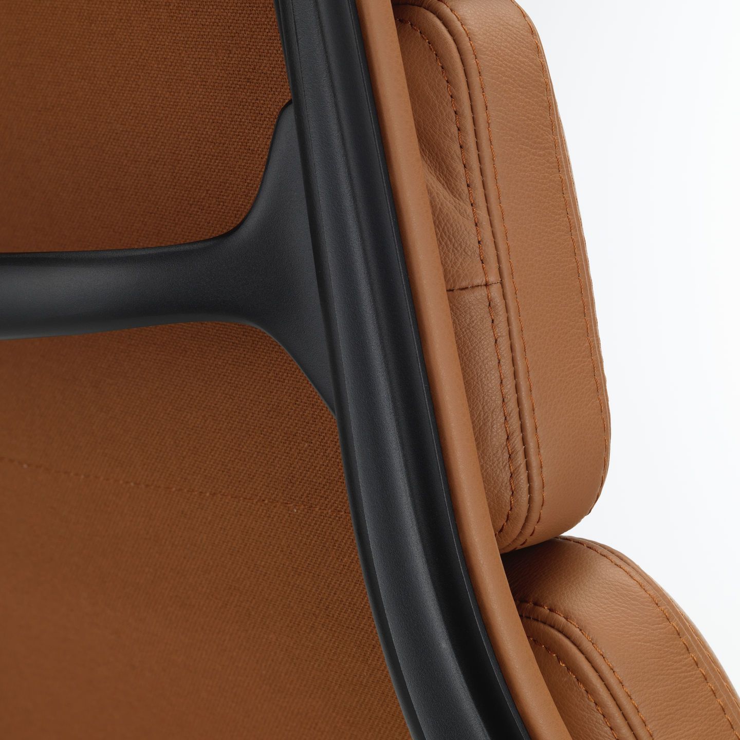 Detailaufnahme der Rückenlehne des Vitra EA 222 Sessels mit braunem Lederbezug und schwarzem Aluminiumrahmen.