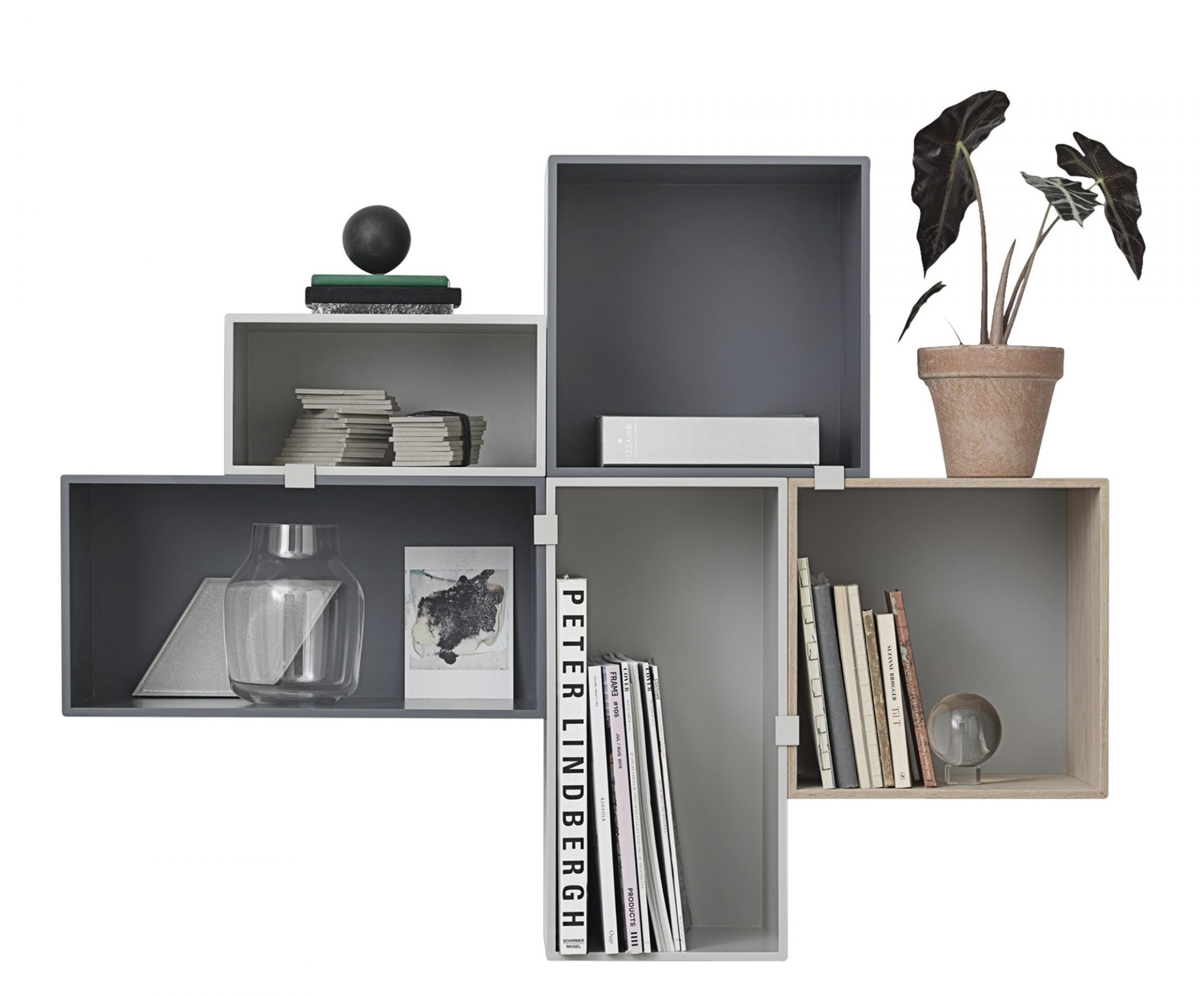 Muuto Mini Stacked Storage System 2.0: Modulares Regalsystem in Grau- und Naturtönen, dekoriert mit Büchern und Zimmerpflanze.