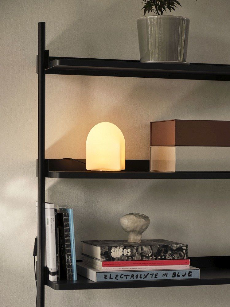 Nahaufnahme der Parade Table Lamp von Hay, eine moderne Tischleuchte auf einem schwarzen Regal.
