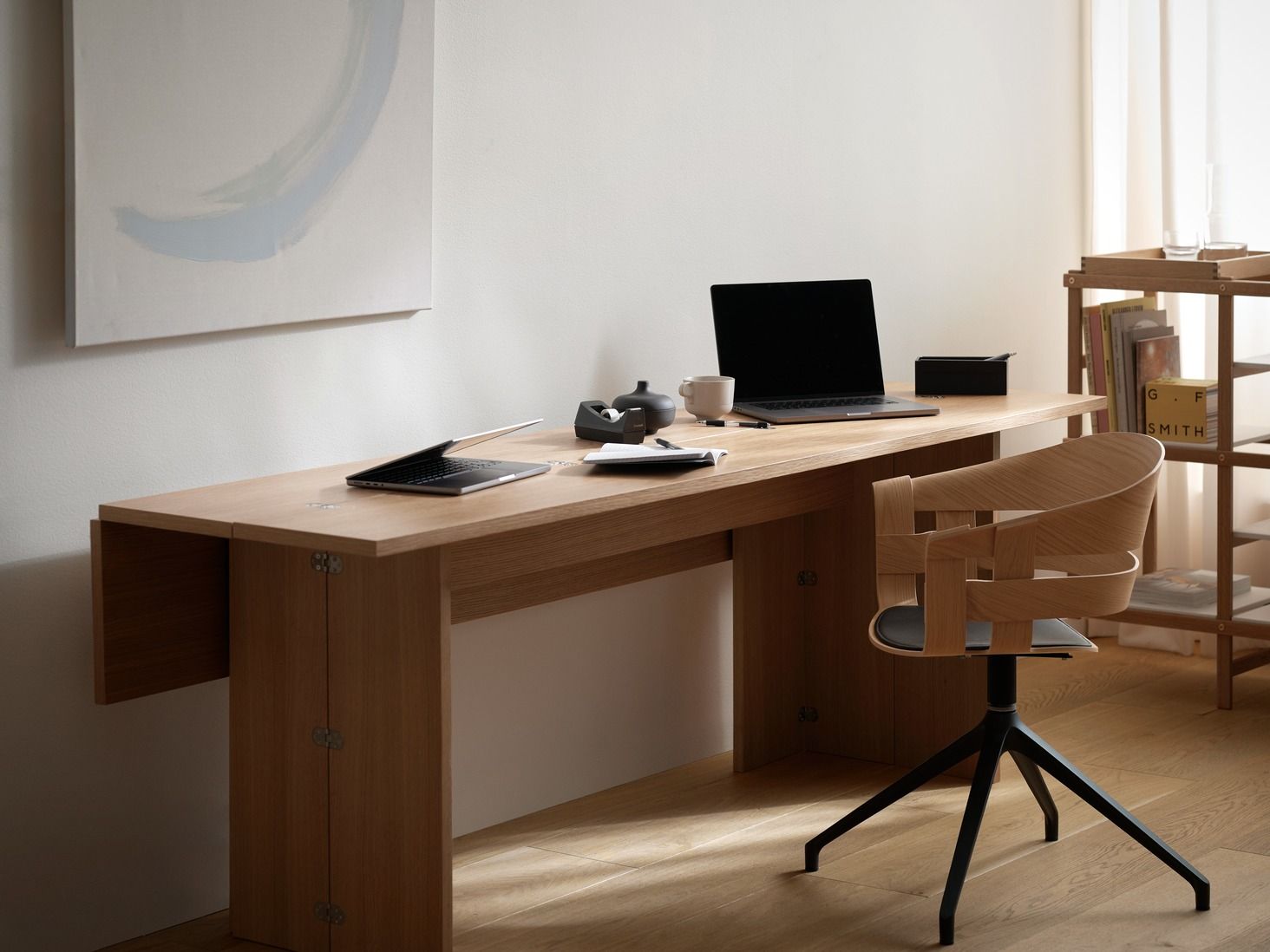 Design House Stockholm Flip Table Klapptisch aus Eichenholz mit Bürostuhl und zwei Laptops.
