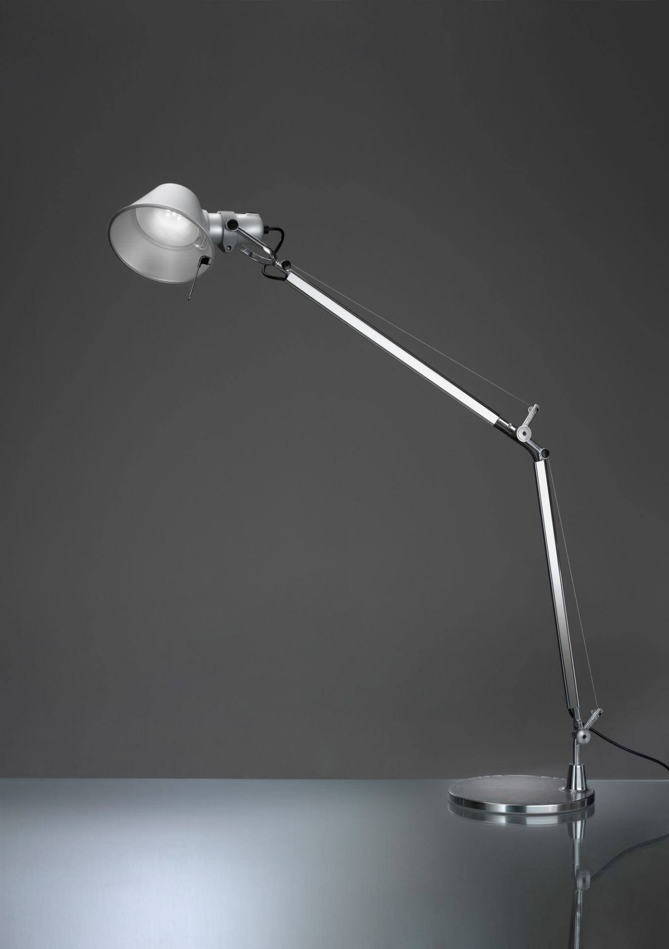 Silberne Tolomeo LED Tischleuchte von Artemide mit verstellbarem Arm und Lampenschirm auf Tisch.