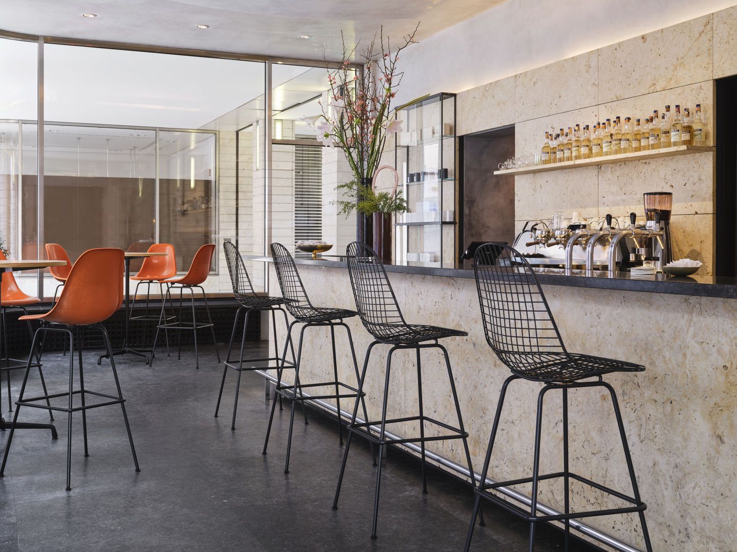 Eames Wire Bar Stool von Vitra in einer Bar, schwarzes Drahtgestell, hoher Hocker.