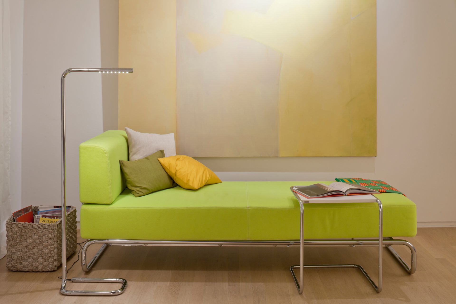 B97 Thonet Beistelltisch mit Stahlrohrgestell neben grüner Ottomane und Stehlampe im modernen Wohnzimmer.