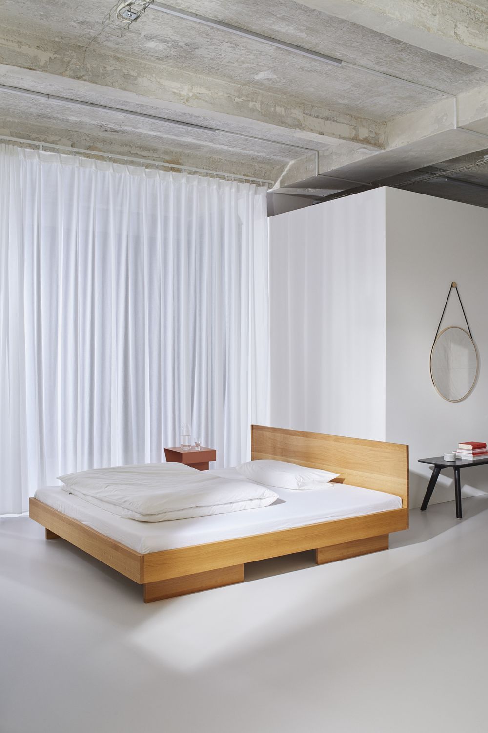 ZIANS Bett Large mit hellem Holzrahmen, niedrigem Kopfteil und geteilten Füßen in minimalistischem Schlafzimmer.