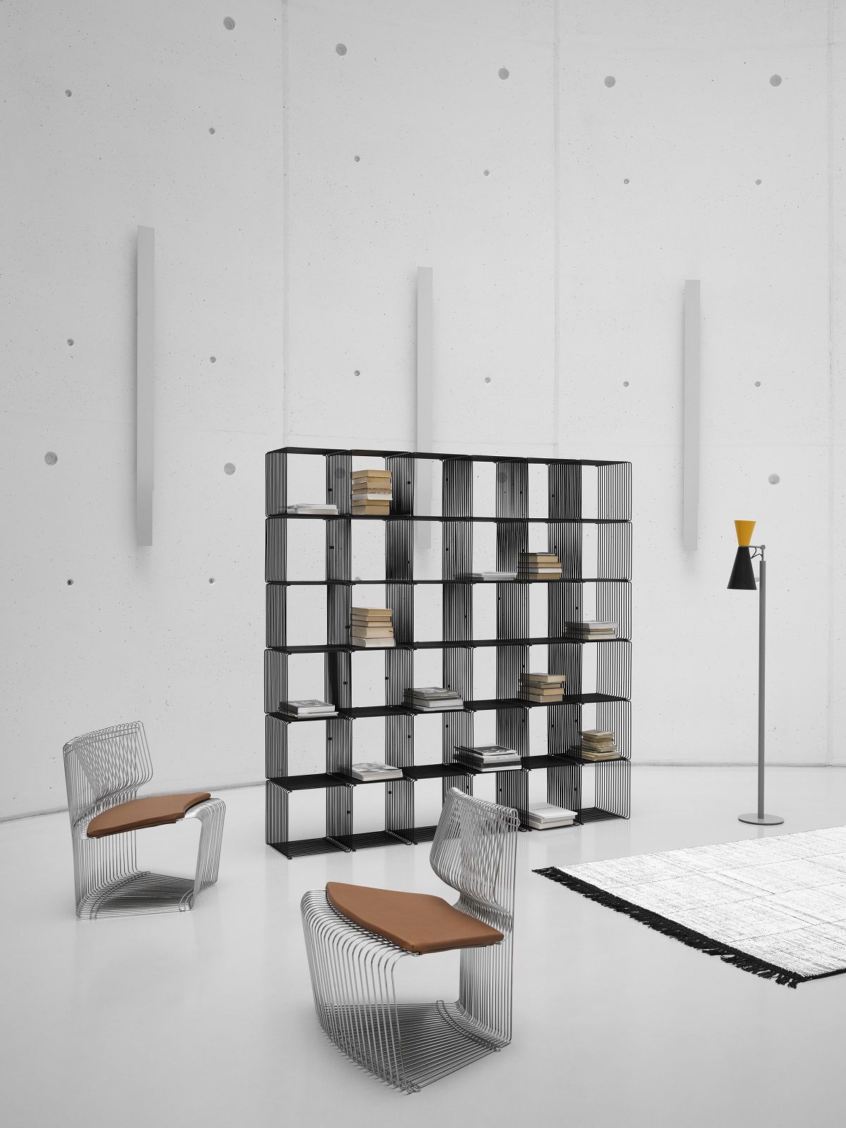 Pantonova System Sitzmodul und Montana Drahtstuhl in minimalistischem Raum mit Regal, Lampe und Teppich.