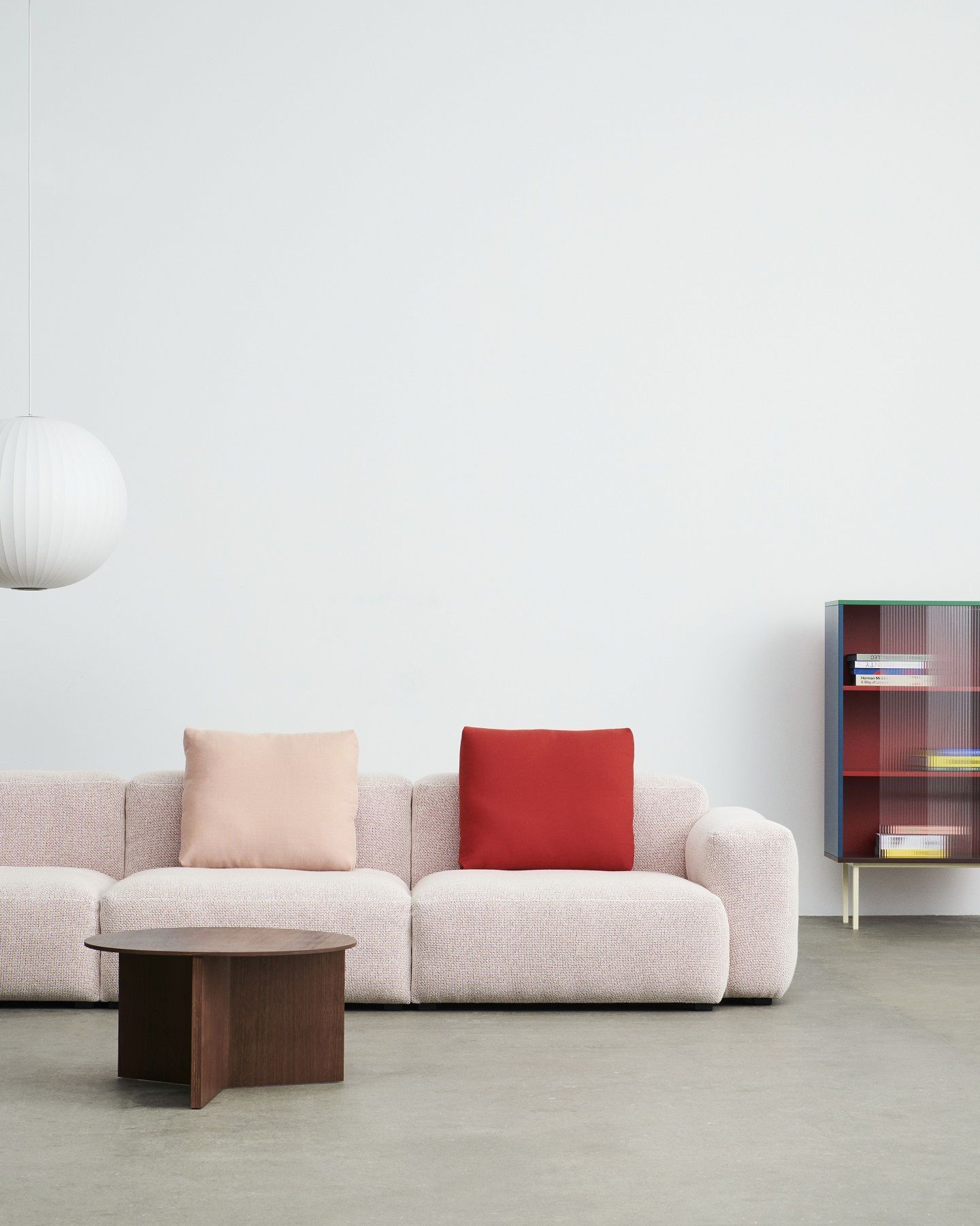 Nahaufnahme des Hay Slit Table Wood Round XL Beistelltisches aus dunklem Holz vor einem Sofa.