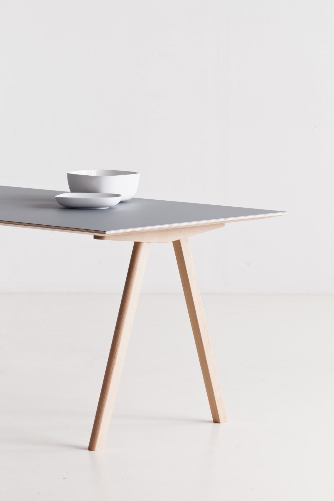Copenhague Table CPH 10 von Hay: Moderner Esstisch mit grauer Tischplatte und hellem Holzgestell.