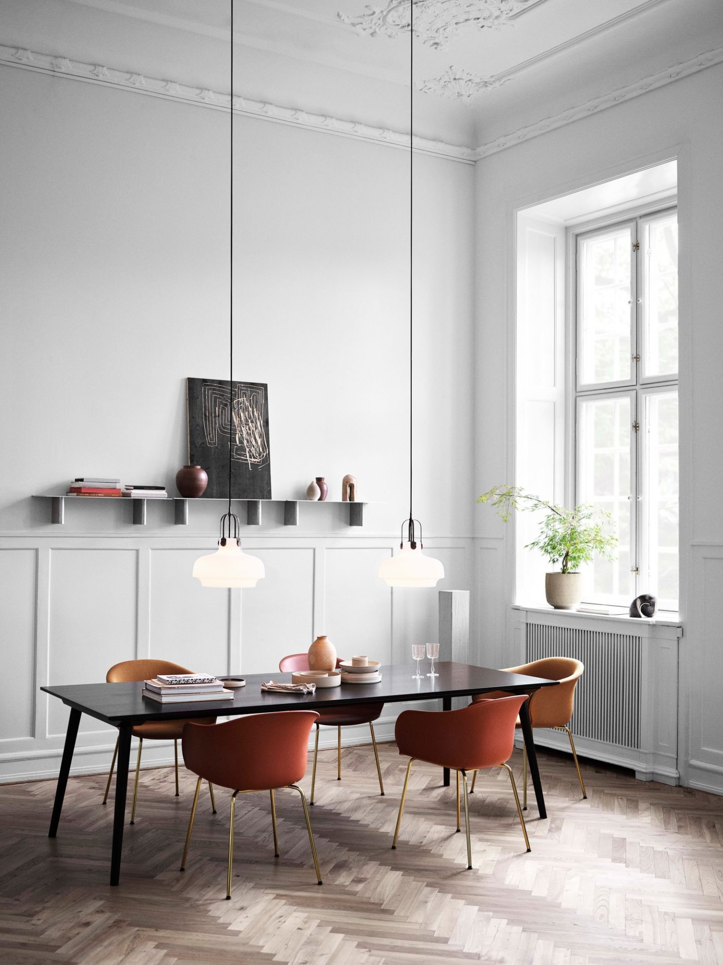 Esszimmer mit Copenhagen SC7 Pendelleuchten von AndTradition über einem Esstisch mit Stühlen.
