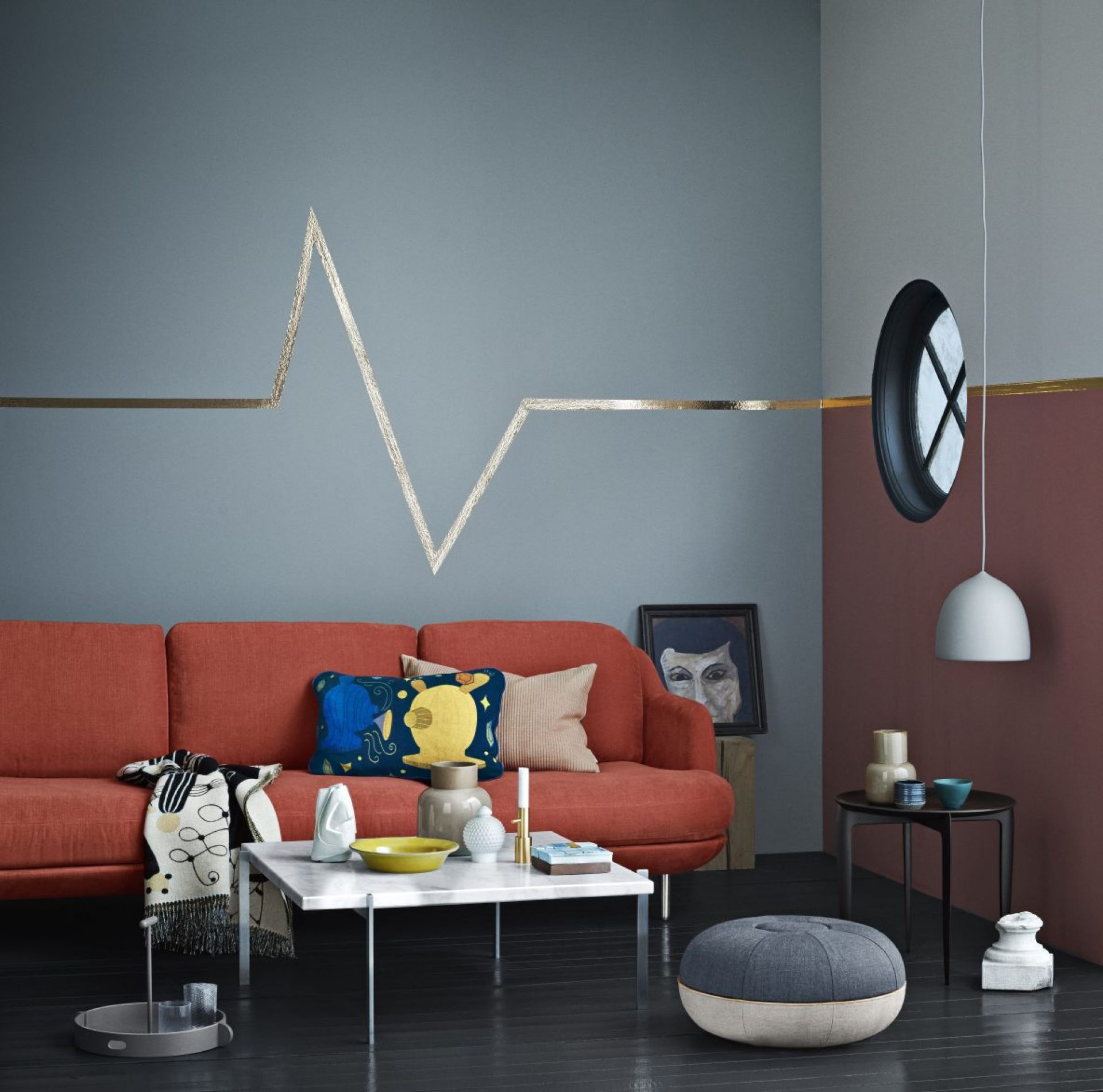 Wohnzimmer-Szene mit rotem Sofa, Marmor-Couchtisch (PK 61 Fritz Hansen) und dekorativen Elementen für modernes Interieur.