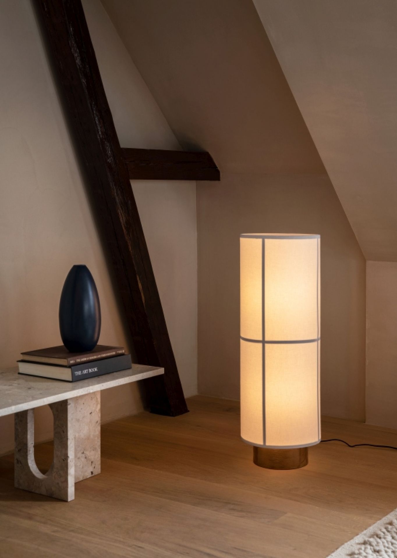 Audo Hashira Stehleuchte: Zylindrische Stofflampe mit warmem Licht in einem stilvollen Interieur.