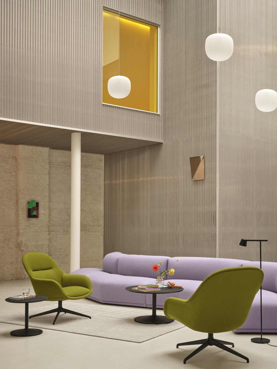 Wohnzimmer mit lila Sofa, grünen Sesseln, Beistelltischen und Muuto Gaze Mirror Wandspiegel.