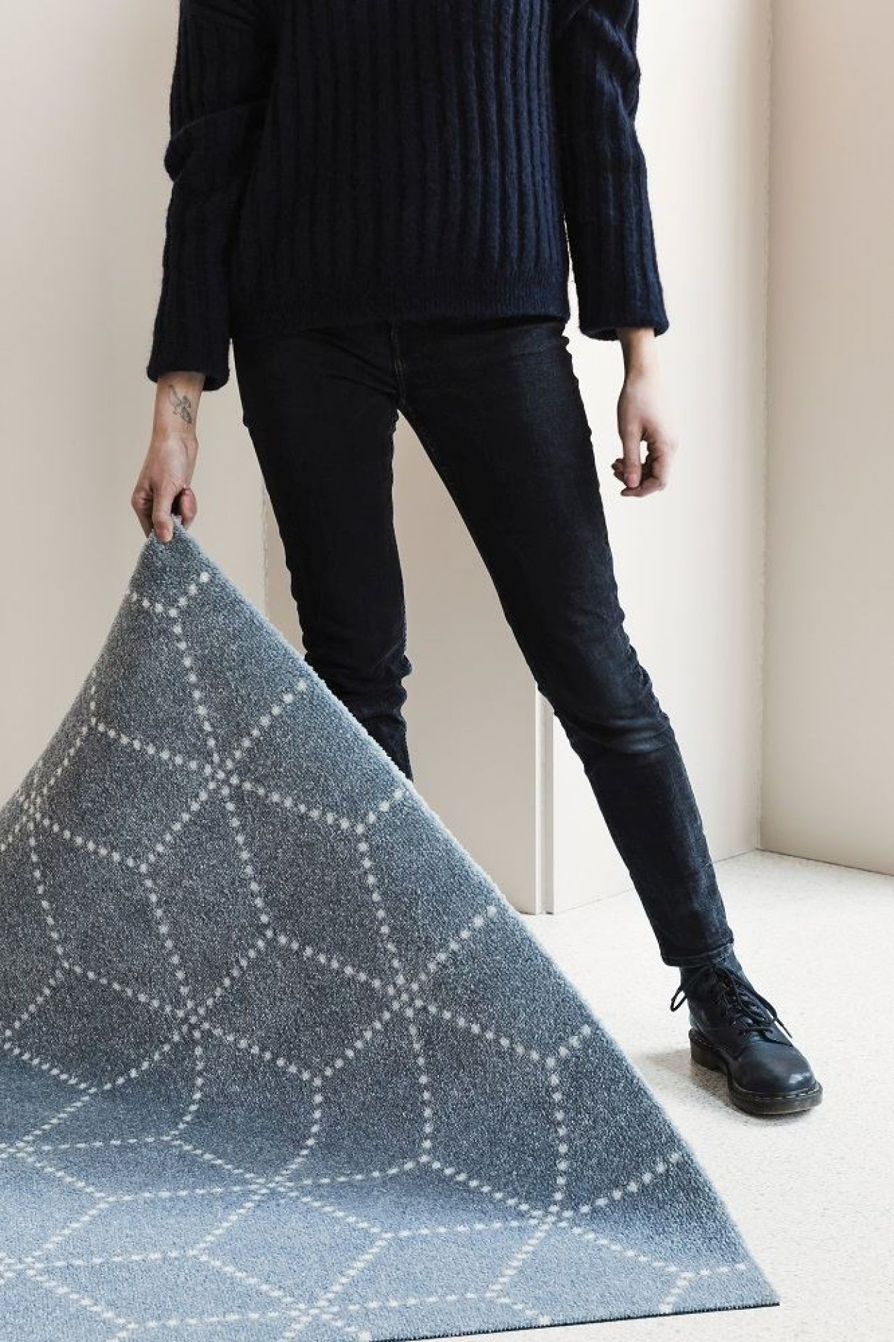 Person hält blaue Hagl Heymat Fußmatte mit geometrischem Muster für Innen und Außen.