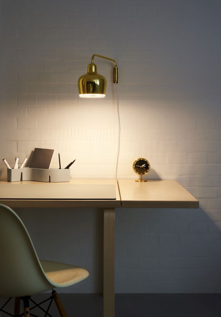 Nahaufnahme der Vitra Night Clock Tischuhr aus Messing auf einem Schreibtisch mit Lampe.