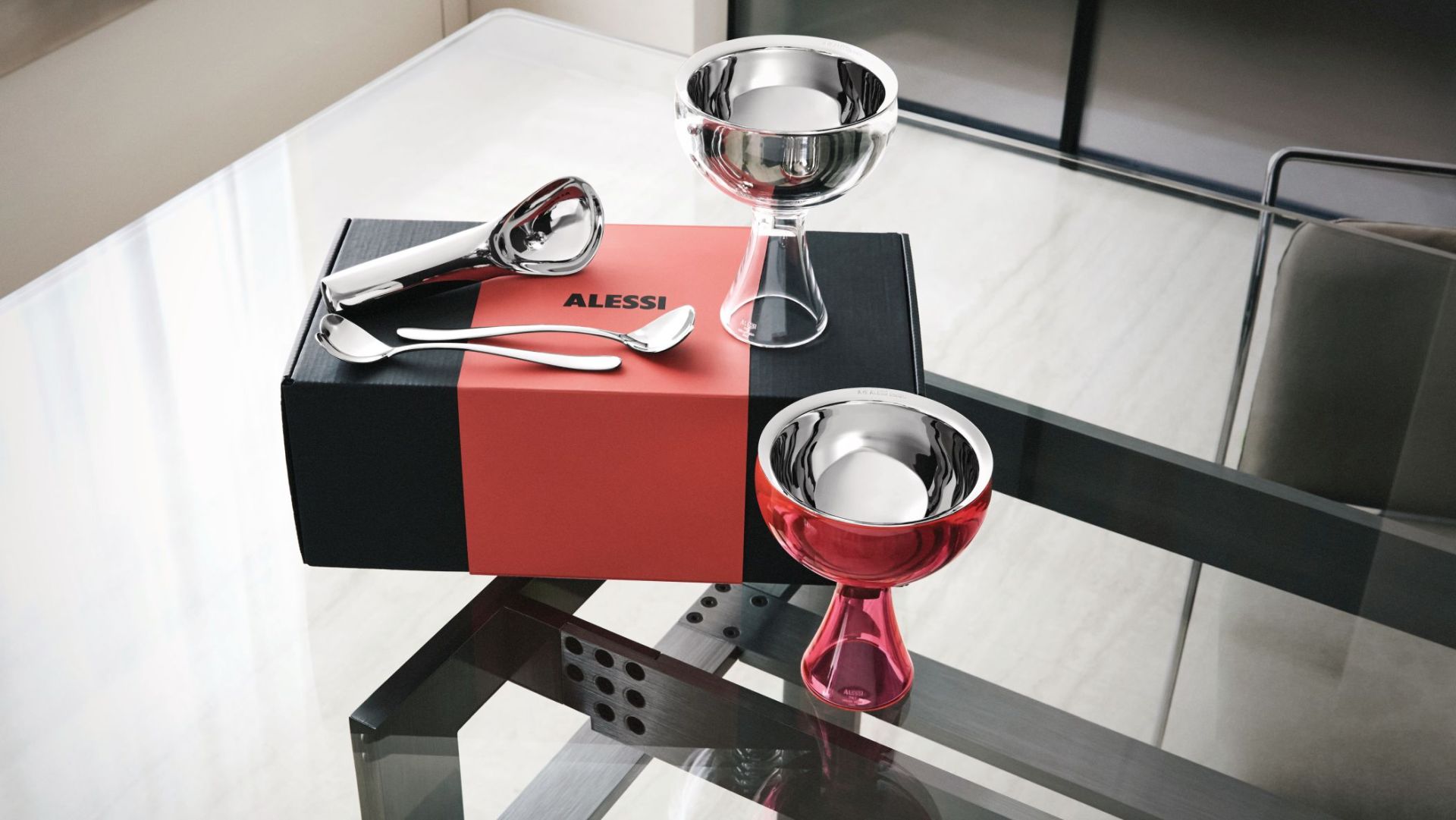 Alessi MMI01SET Eisbecher Set: Zwei Eisbecher, Eislöffel und Eisportionierer auf einer Geschenkbox.