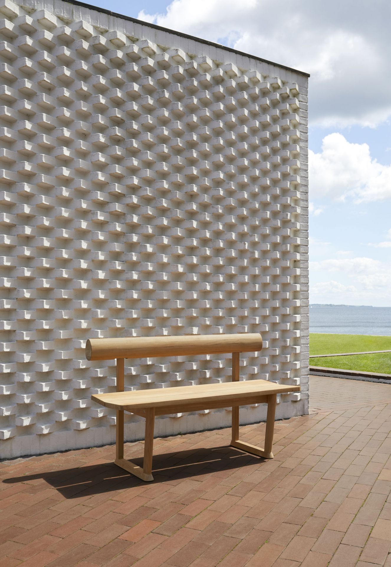 Banco Bank aus Teakholz von Skagerak by Fritz Hansen für den Außenbereich vor einer weißen Wand.