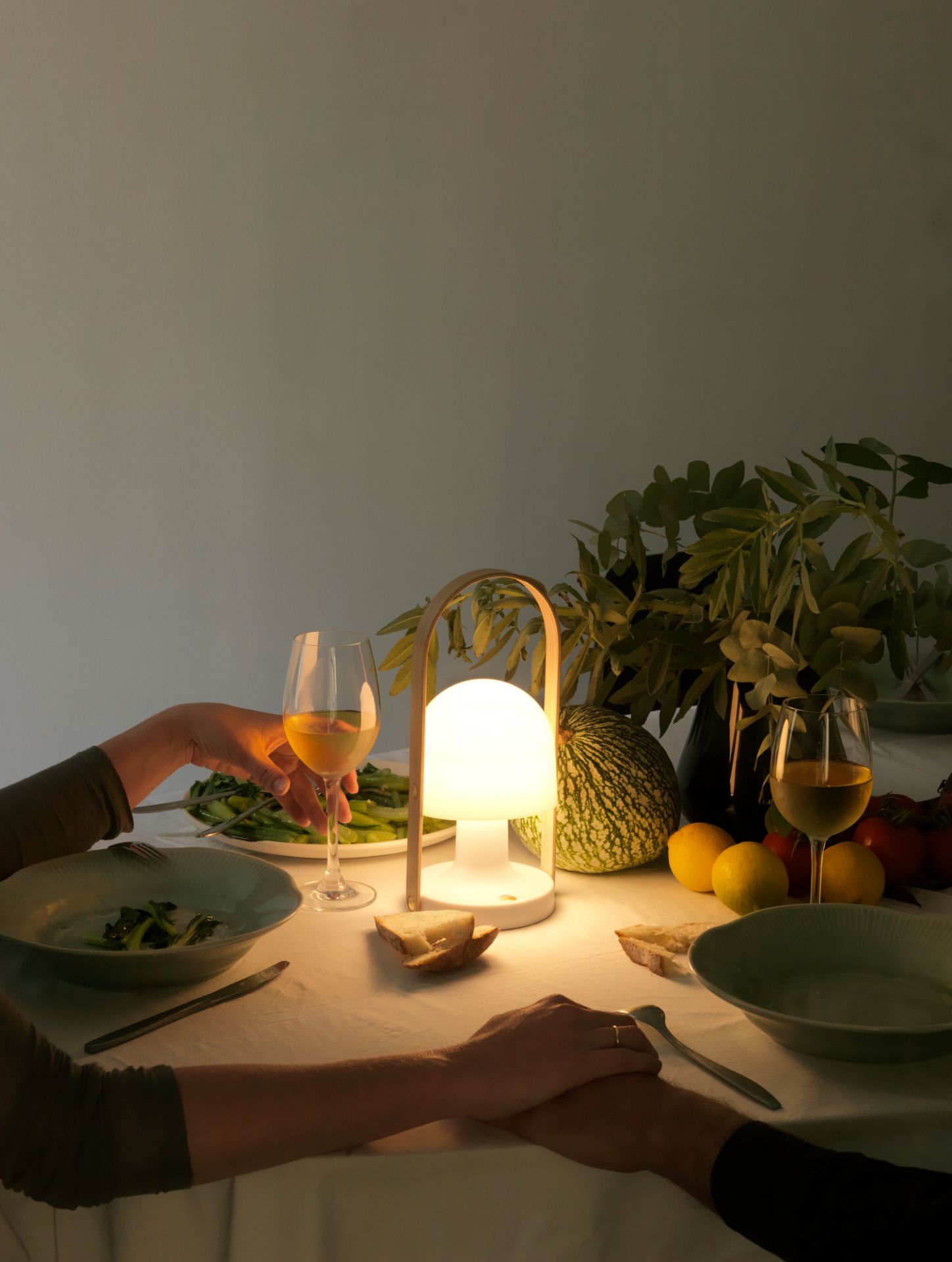 FollowMe LED Tischleuchte in Terrakotta beleuchtet romantisches Abendessen mit Wein und saisonalen Zutaten.