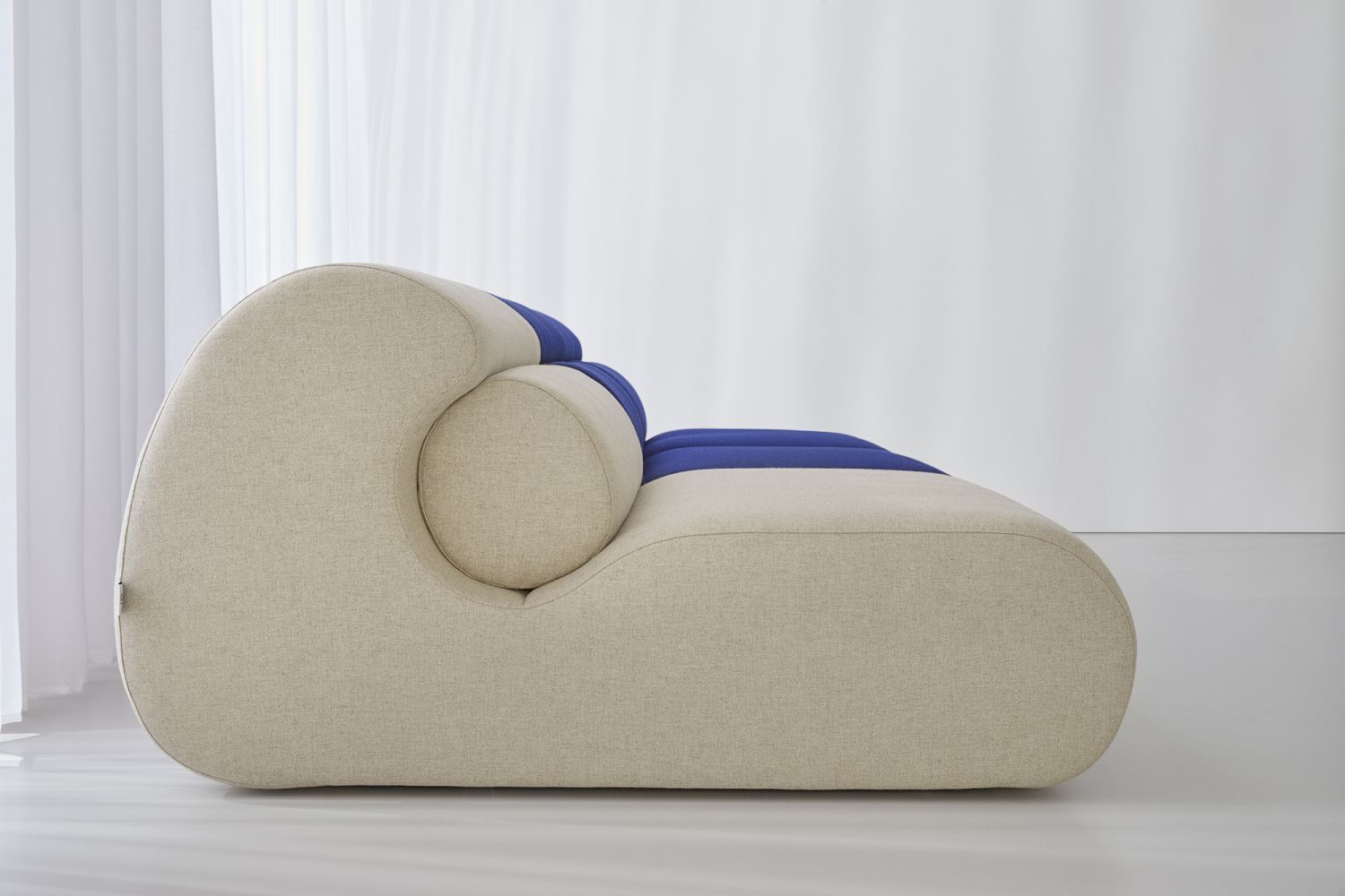 OLA Sofa Pouf OUT, modernes Sitzmöbel in Beige und Blau, Seitenansicht im minimalistischen Interieur.