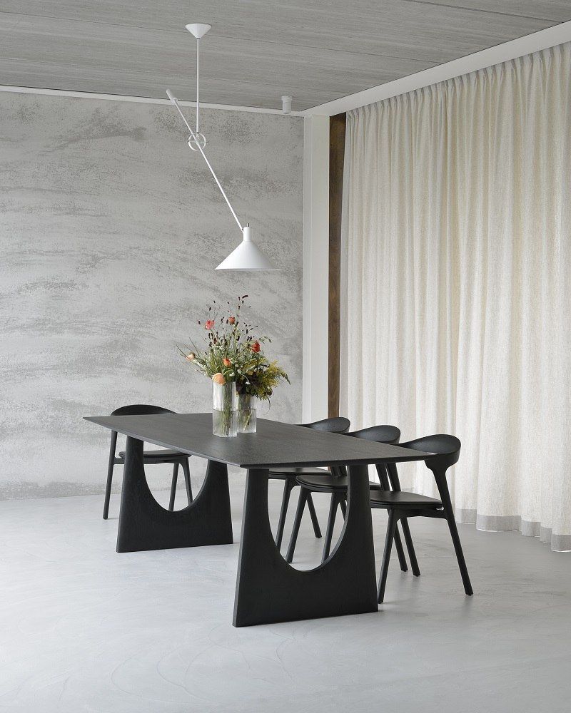 Ethnicraft Geometric Esstisch aus Eiche, schwarz, mit passenden Stühlen und Blumenvase in modernem Esszimmer.