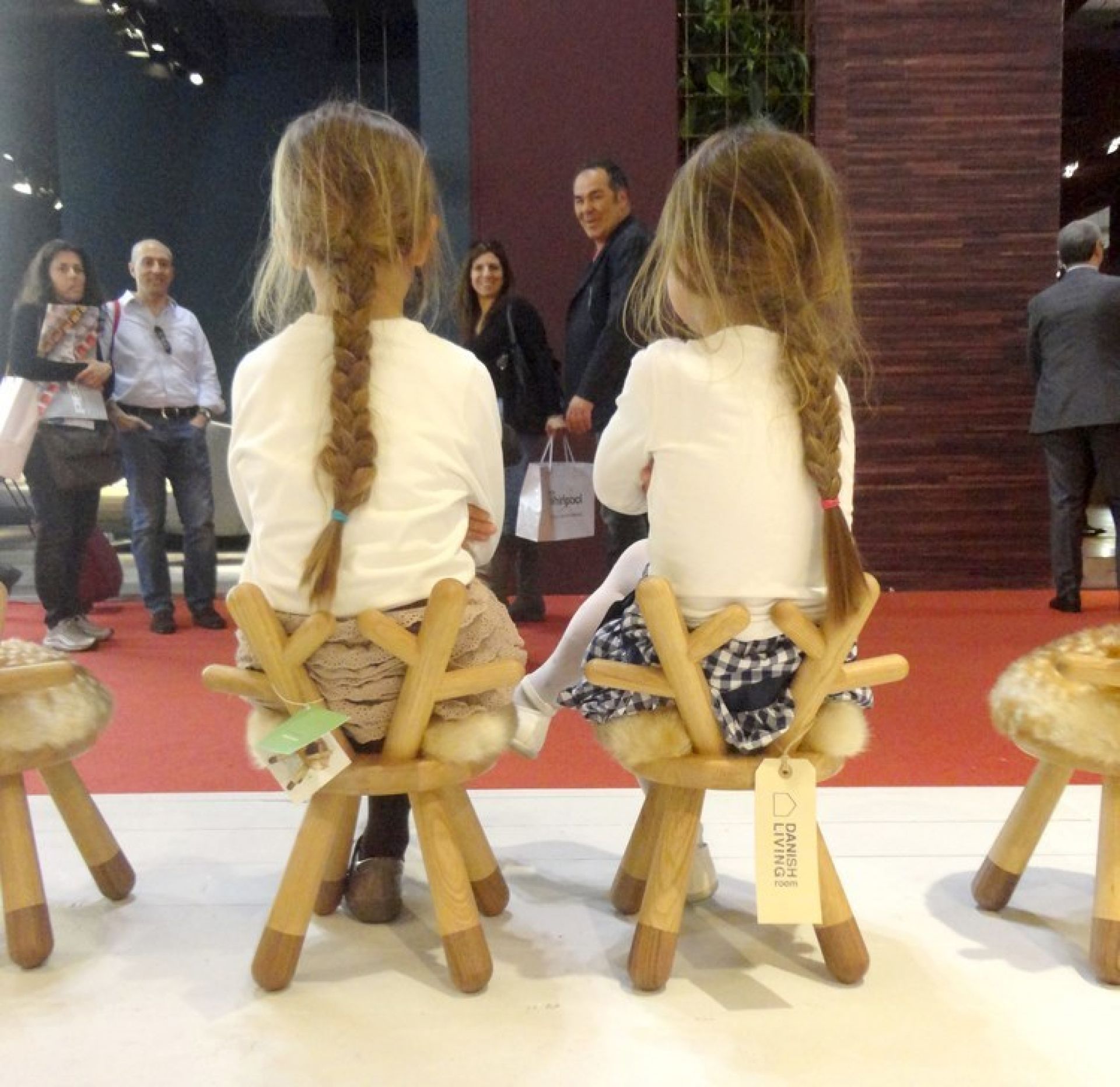 Zwei Mädchen sitzen auf Bambi Chair Kinderstühlen mit Geweih-Lehne und Fell-Sitzfläche.