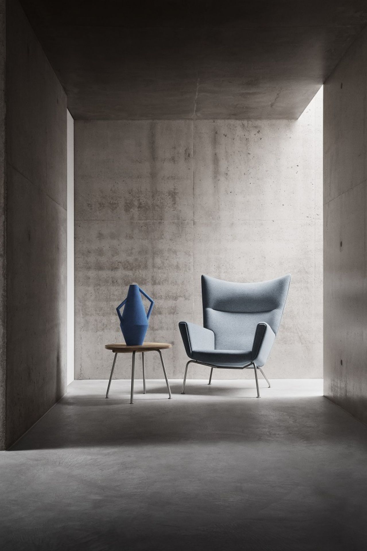 CH445 Wing Chair Sessel von Carl Hansen & Søn, hellblau, mit Beistelltisch und blauer Vase.