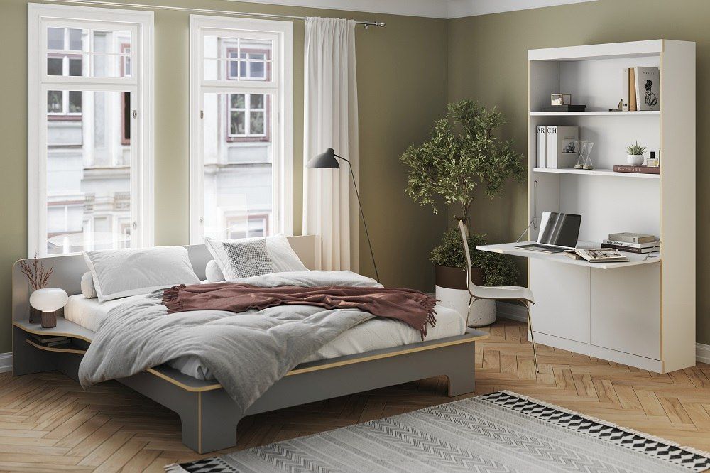 Modernes Schlafzimmer mit FLAI Home-Office Sekretär von Müller Möbelwerkstätten, Bett, Regal und Schreibtisch in Weiß.