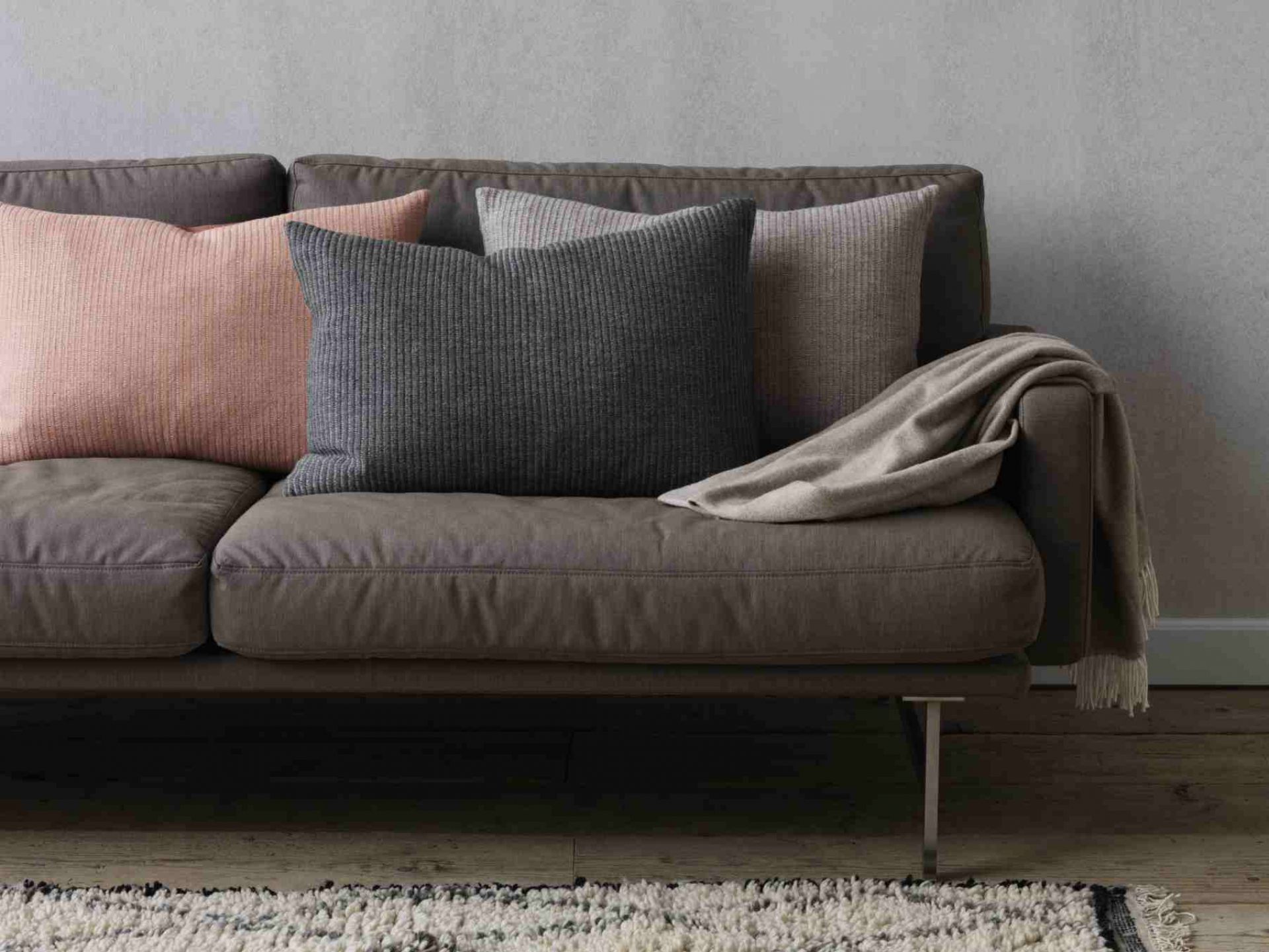 Lissoni Sofa von Fritz Hansen in Grau mit Zierkissen und Decke.