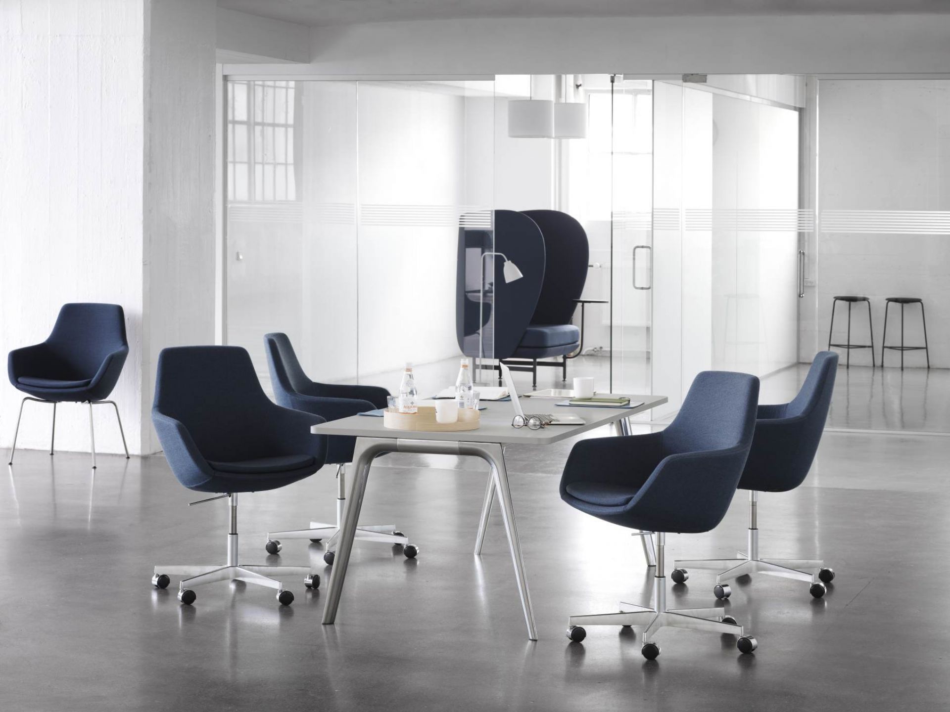 Blauer Little Giraffe Drehstuhl von Fritz Hansen um einen Konferenztisch in einem modernen Büro.