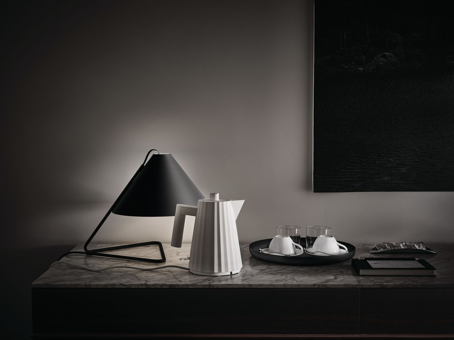 Weißer Alessi Plissé Wasserkocher auf Marmortisch mit Lampe und Tassen. Design Wasserkocher.