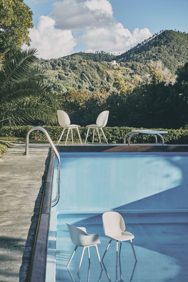 Beige Beetle Chair Outdoor Esszimmerstühle von Gubi am Pool mit Bergpanorama. Gartenmöbel für Draußen.