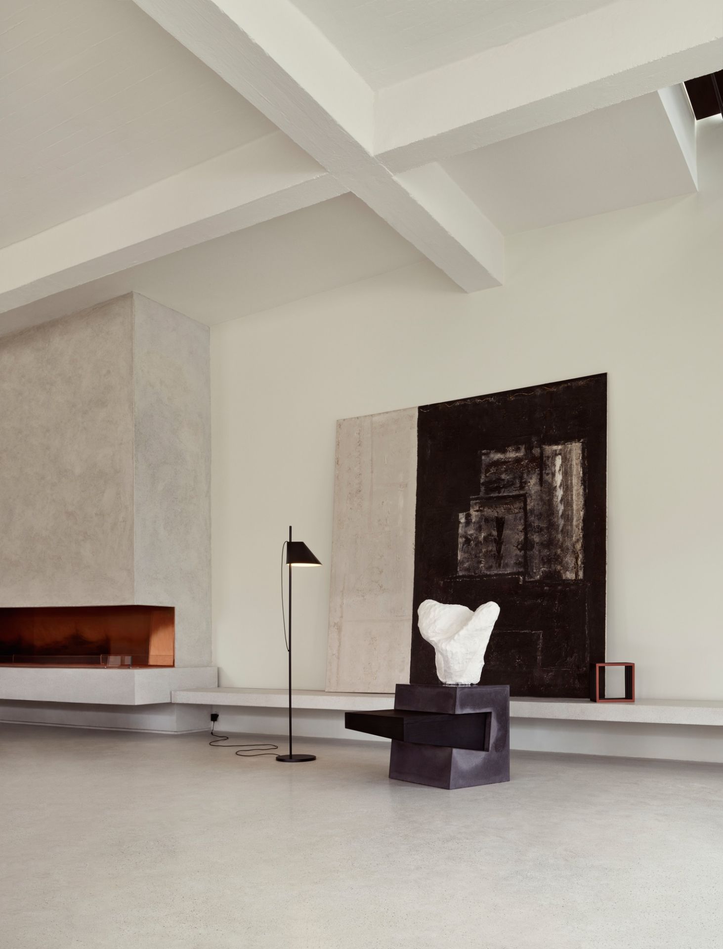Schwarze Yuh LED Stehleuchte von Louis Poulsen in modernem Wohnzimmer mit Kamin und Kunst.