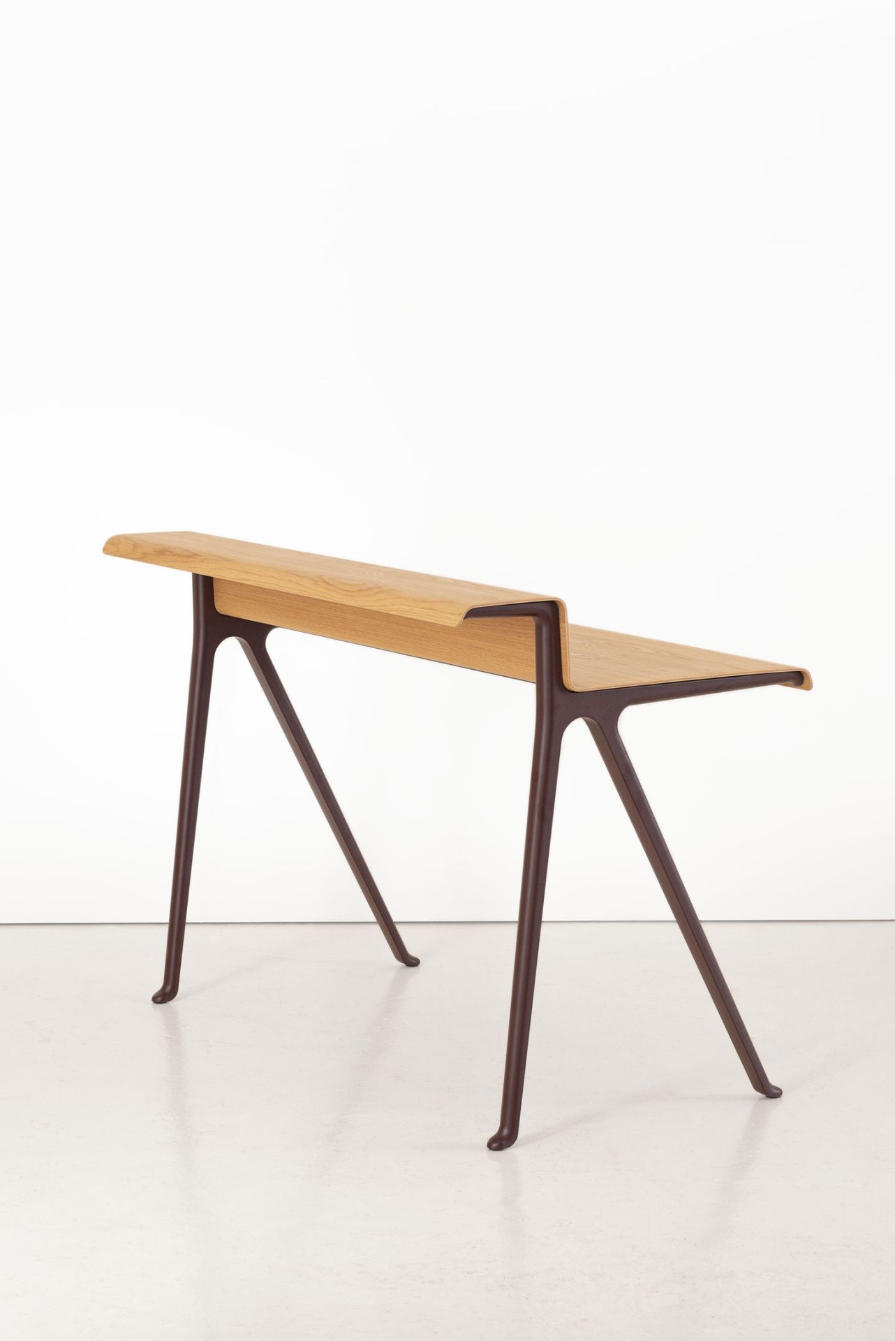 Vitra Courier Schreibtisch aus hellem Holz mit braunem Gestell vor weißem Hintergrund.