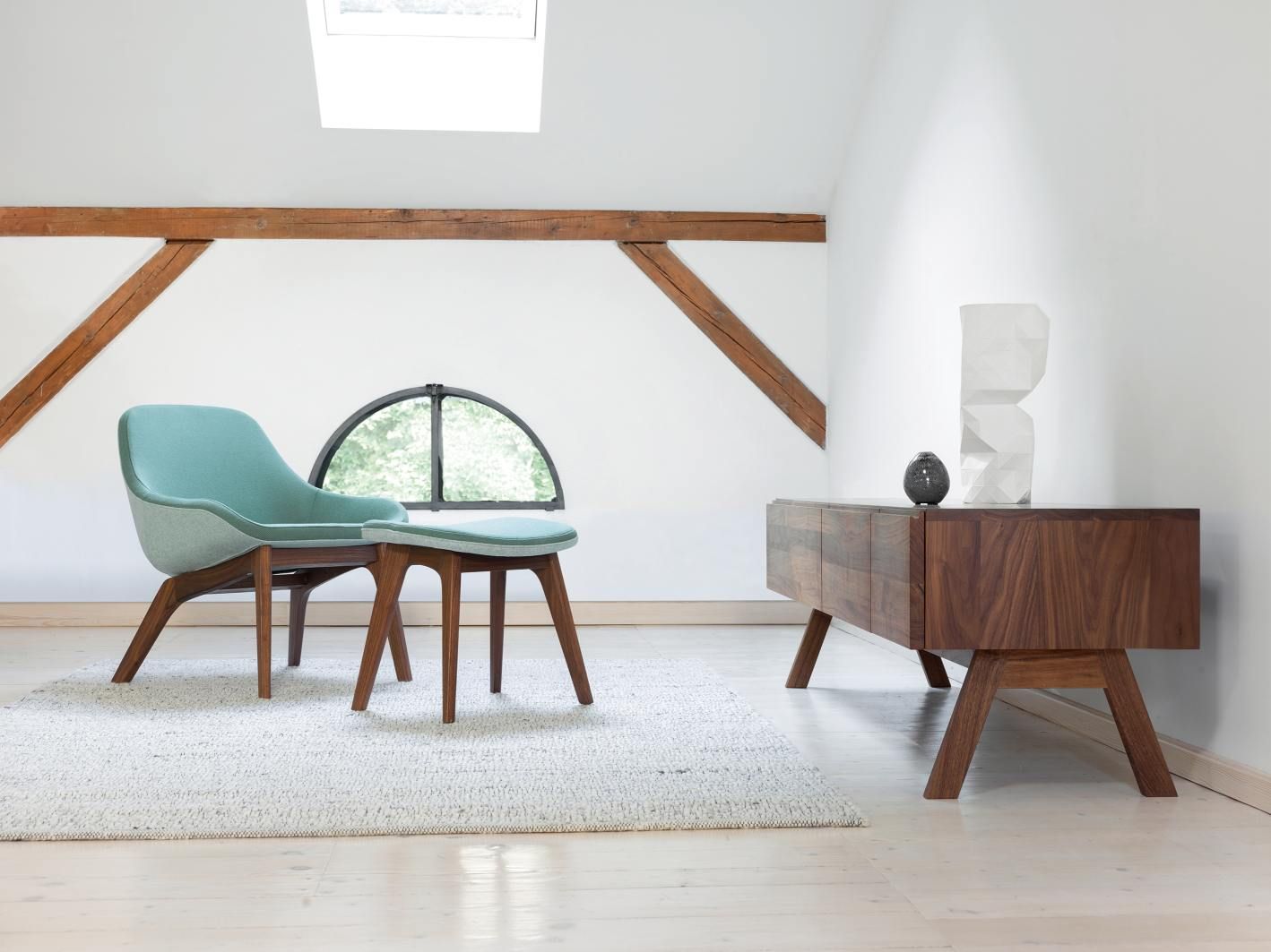 Morph Lounge Chair Sessel von Zeitraum in Türkis mit passendem Hocker auf hellem Teppich.