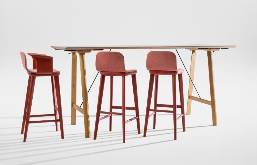 Aeon Comfort Barstool: Rote Barhocker mit Armlehnen und vollgepolstert an einem Bartisch aus Holz.