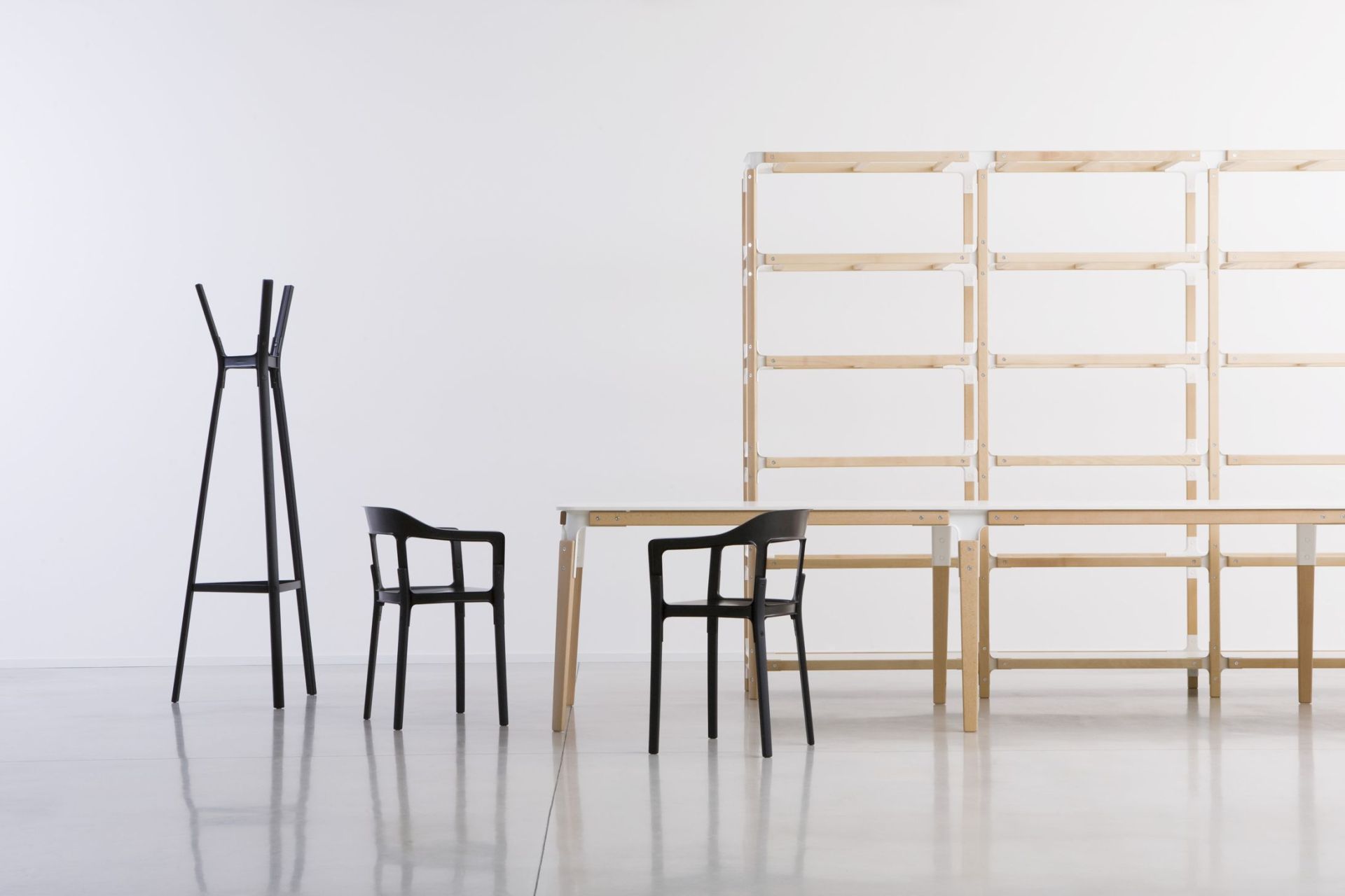 Schwarzer Steelwood Chair Stuhl von Magis neben Garderobenständer und Regalsystem in minimalistischem, hellem Raum.