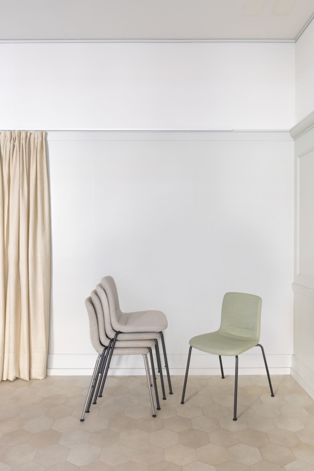 Vitra Hal Soft Tube Stuhl: Stapelbare Stühle in Grau und Grün mit Stahlgestell.