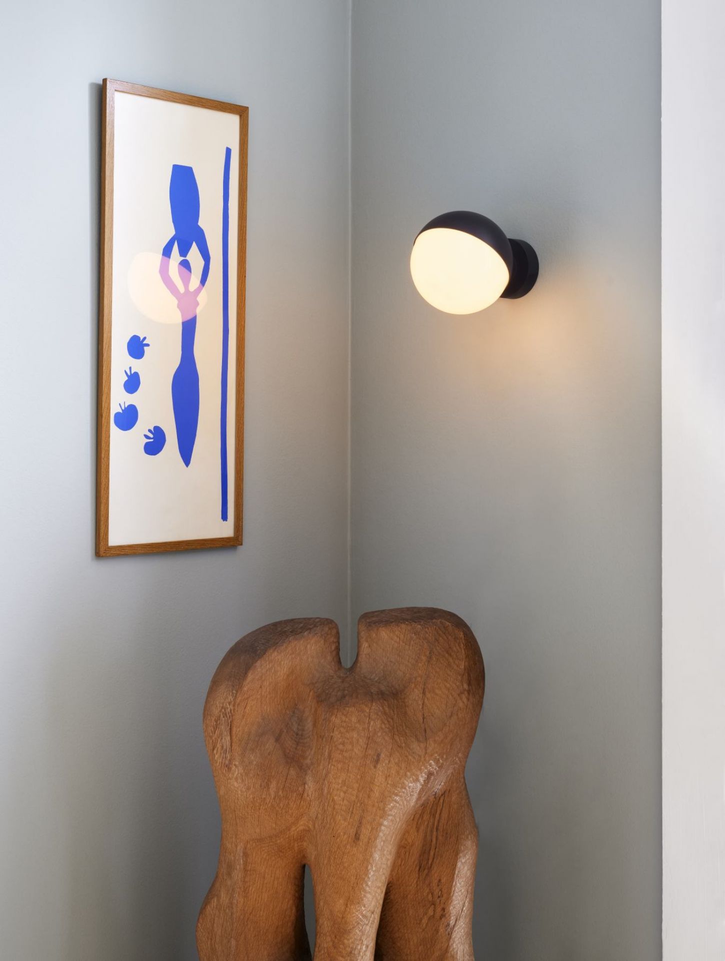Nahaufnahme einer VL Studio Wandleuchte von Louis Poulsen, kombiniert mit Kunstobjekten in einem modernen Interieur.