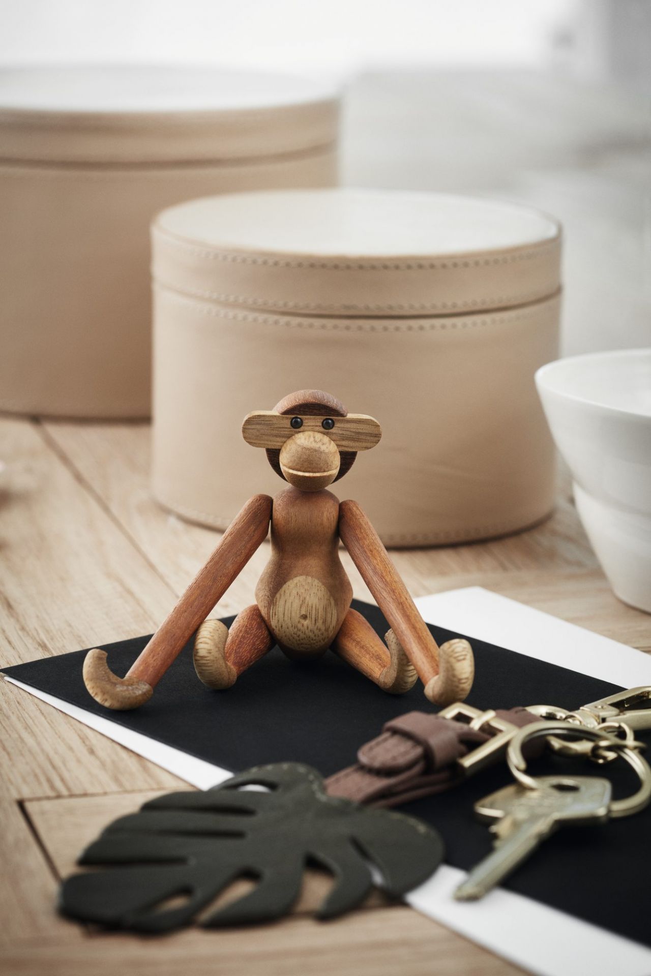 Detailaufnahme: Sitzender Affe Mini Holzfigur von Kay Bojesen aus Teakholz auf einem Schreibtisch.