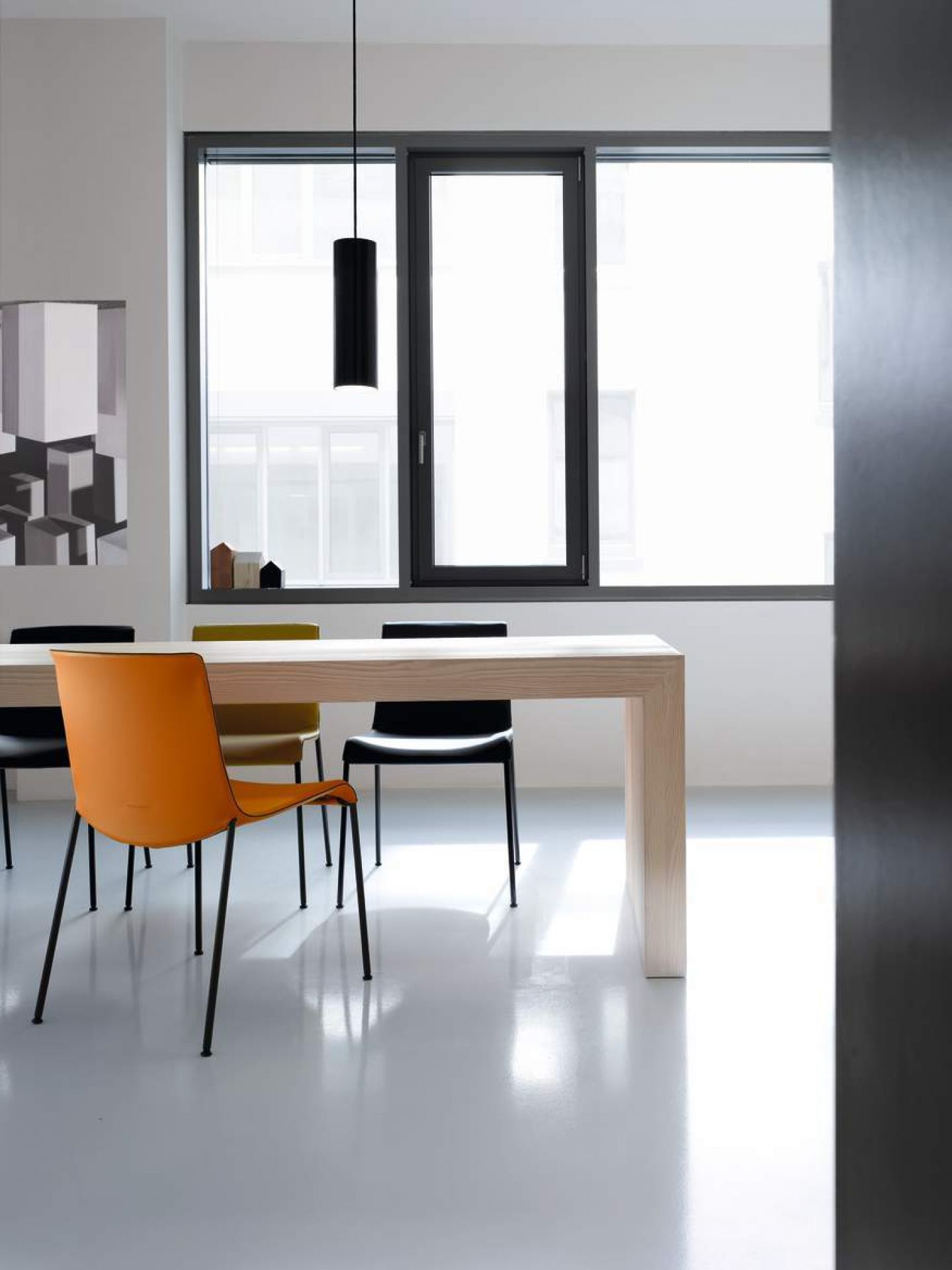 Esszimmer mit Esstisch und mehreren Liz Stühlen von Walter Koll in Orange, Schwarz und Gelb.