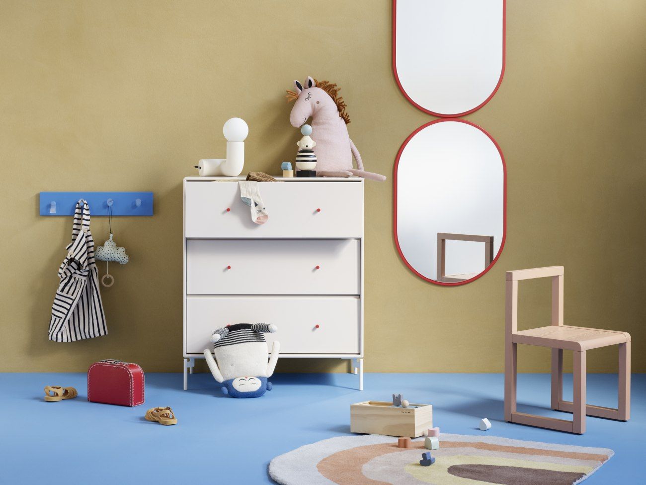 Kinderzimmer-Szene mit Montana Spiegel mit farbigem Rahmen in Fjord, Kommode und Spielzeug.