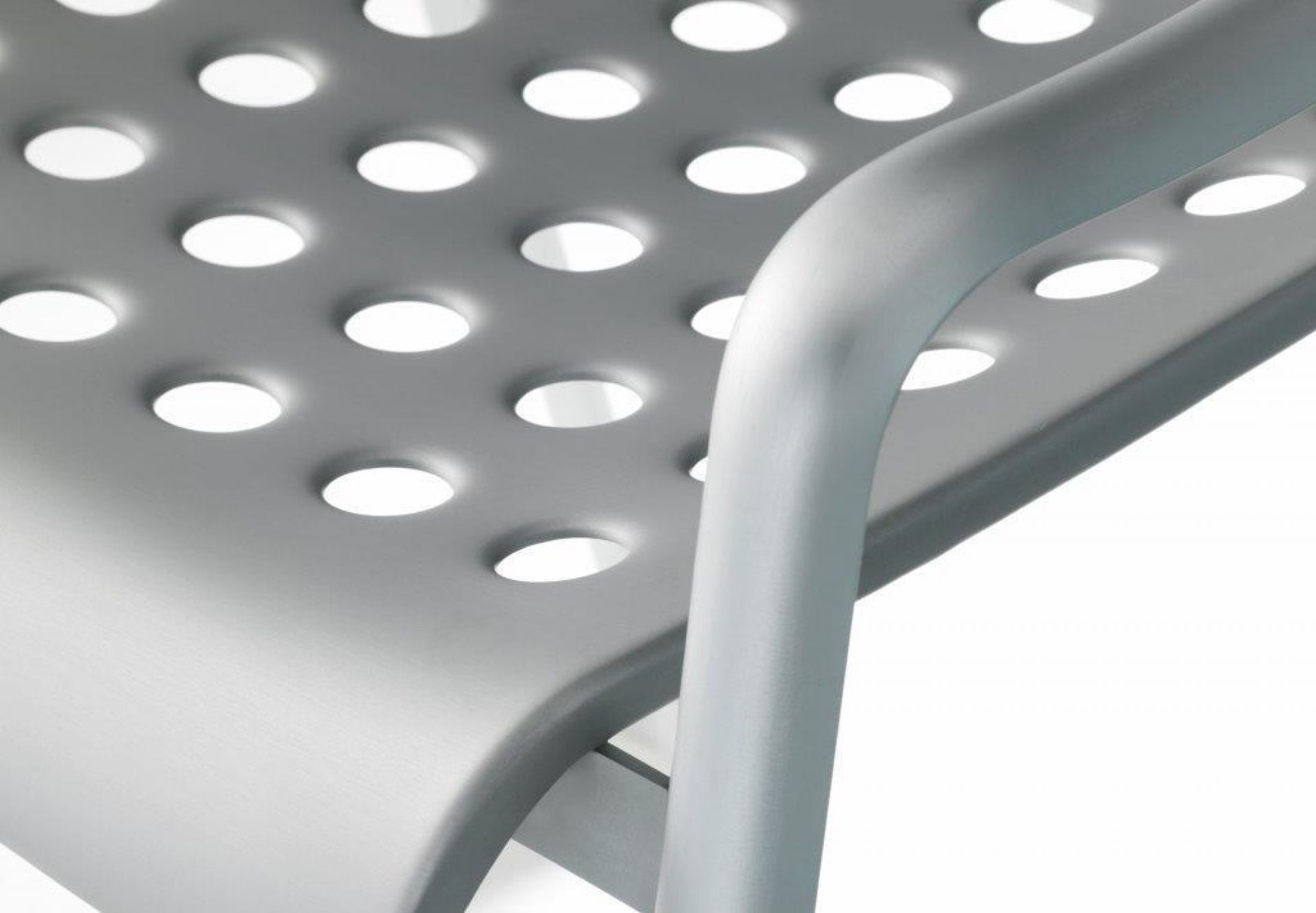 Detailaufnahme des Landi Stuhls von Vitra, Sitzfläche aus Aluminium mit charakteristischen Lochmuster und Armlehne.