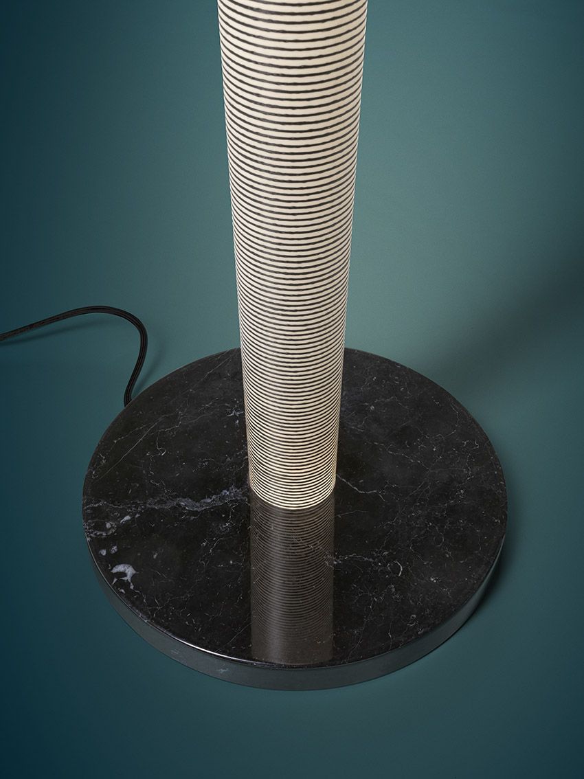 Detailaufnahme der Mite Stehleuchte von Foscarini mit gestreiftem Schirm und Marmorfuß.