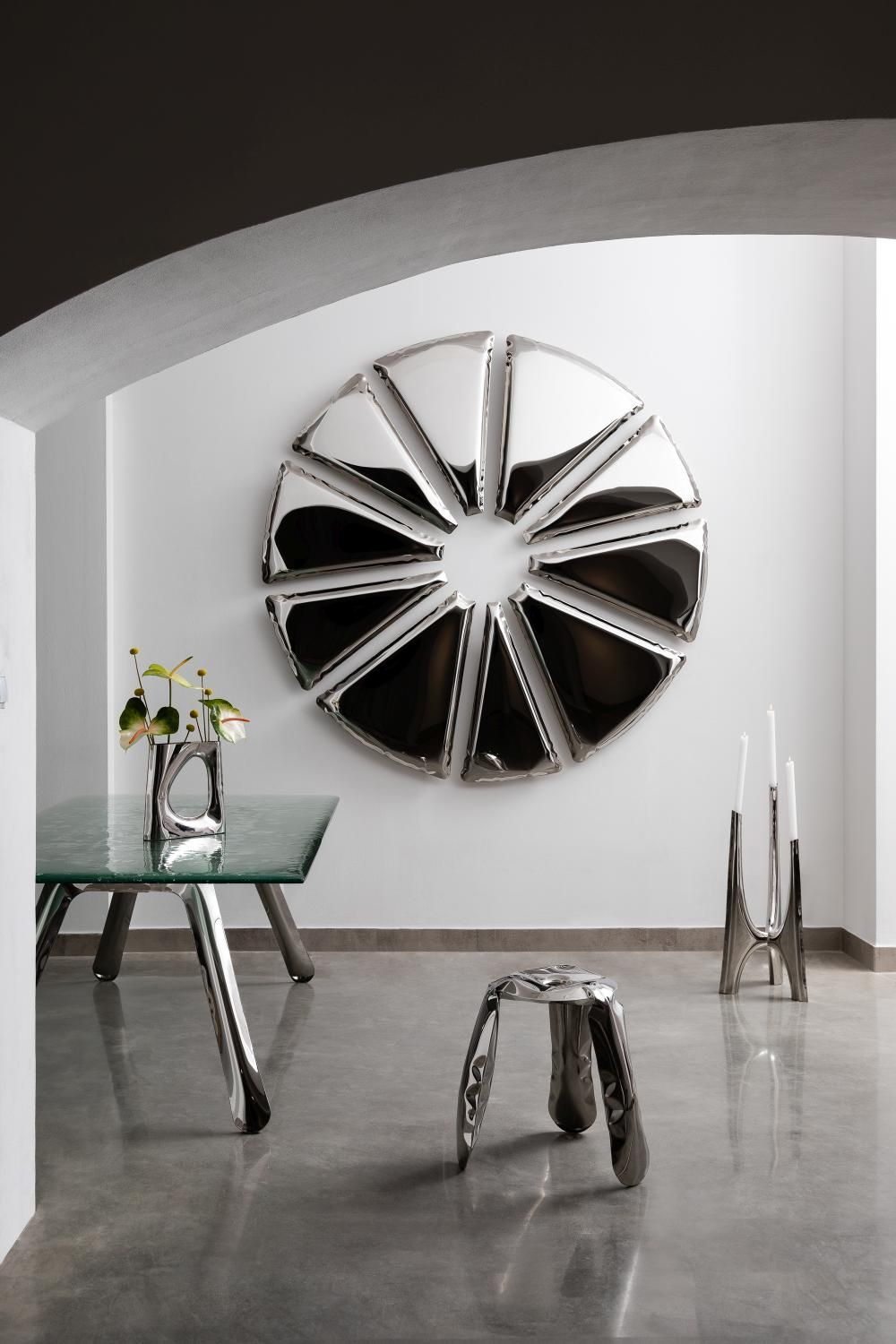 Nucleus Spiegel von Zieta, ein runder, silberner Design-Spiegel an einer weißen Wand.