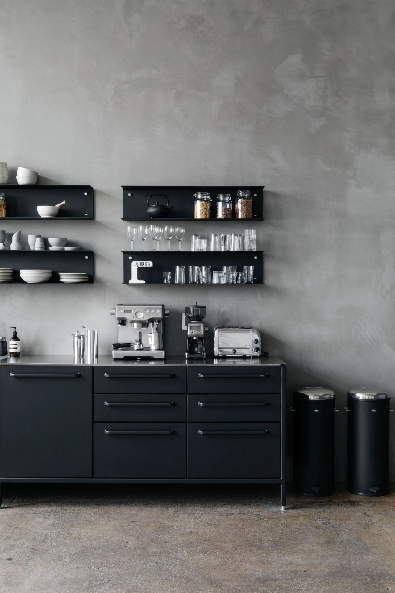 Zwei schwarze Vipp Treteimer 30 Liter mit Edelstahldeckel in moderner Küche neben schwarzem Sideboard.